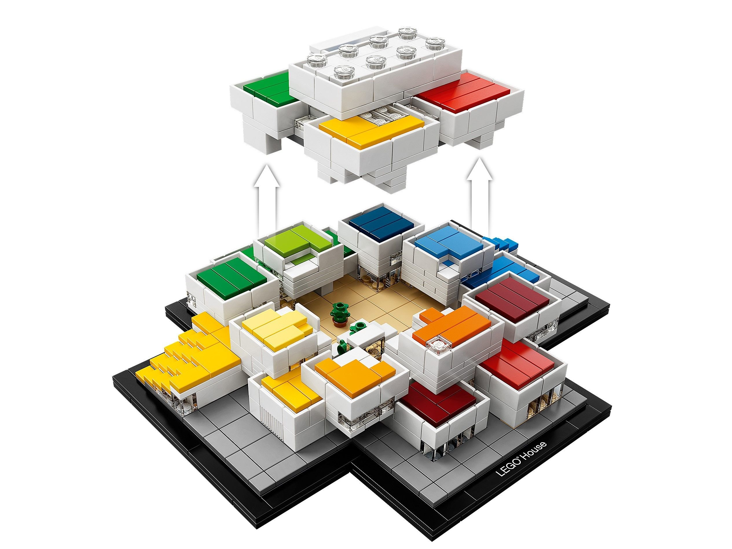 Sökülebilir bölümleri olan bir Lego ev modeli, siyah ve gri bir tabana yerleştirilmiş.