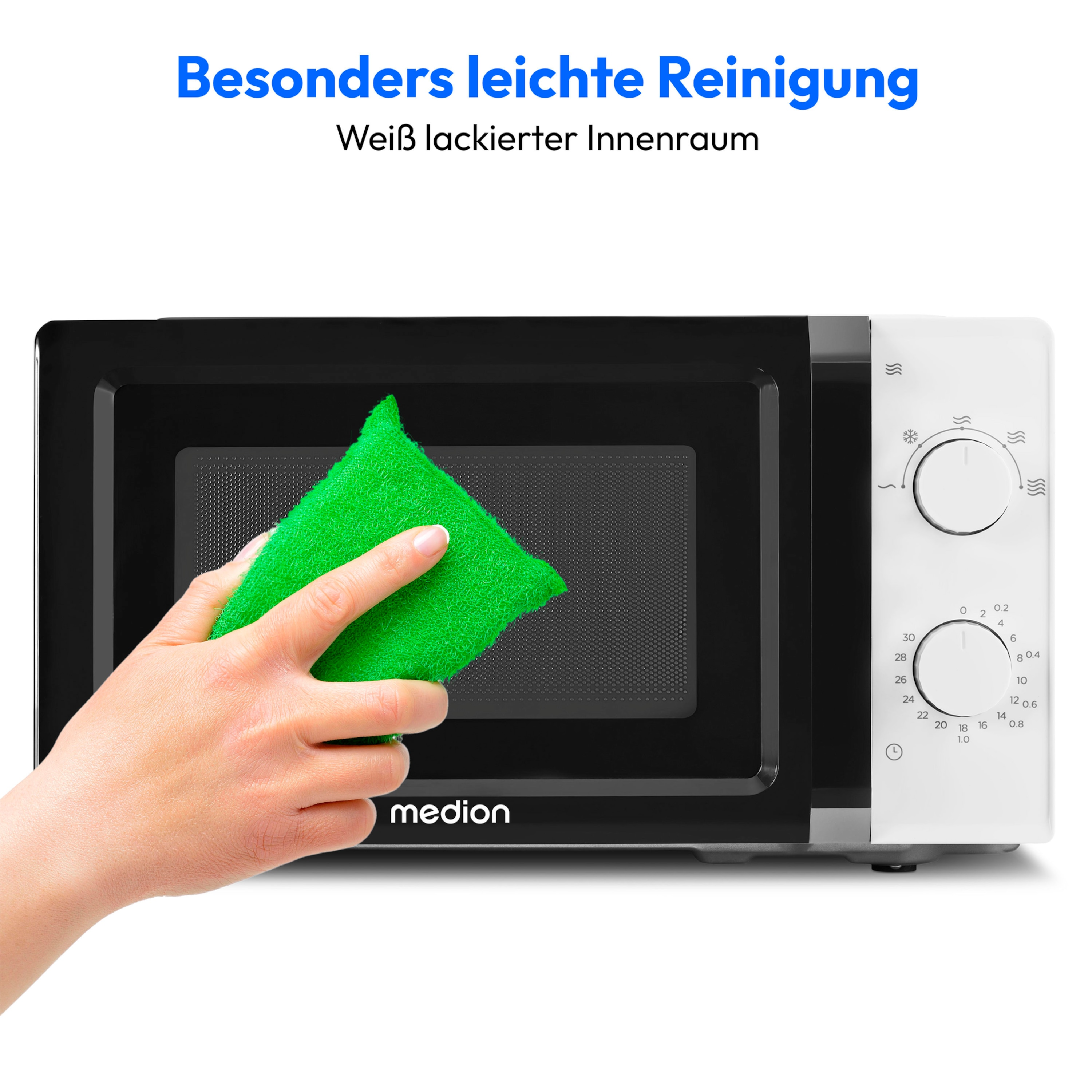 Czarno-biała kuchenka mikrofalowa z dłonią czyszczącą ją zieloną gąbką.