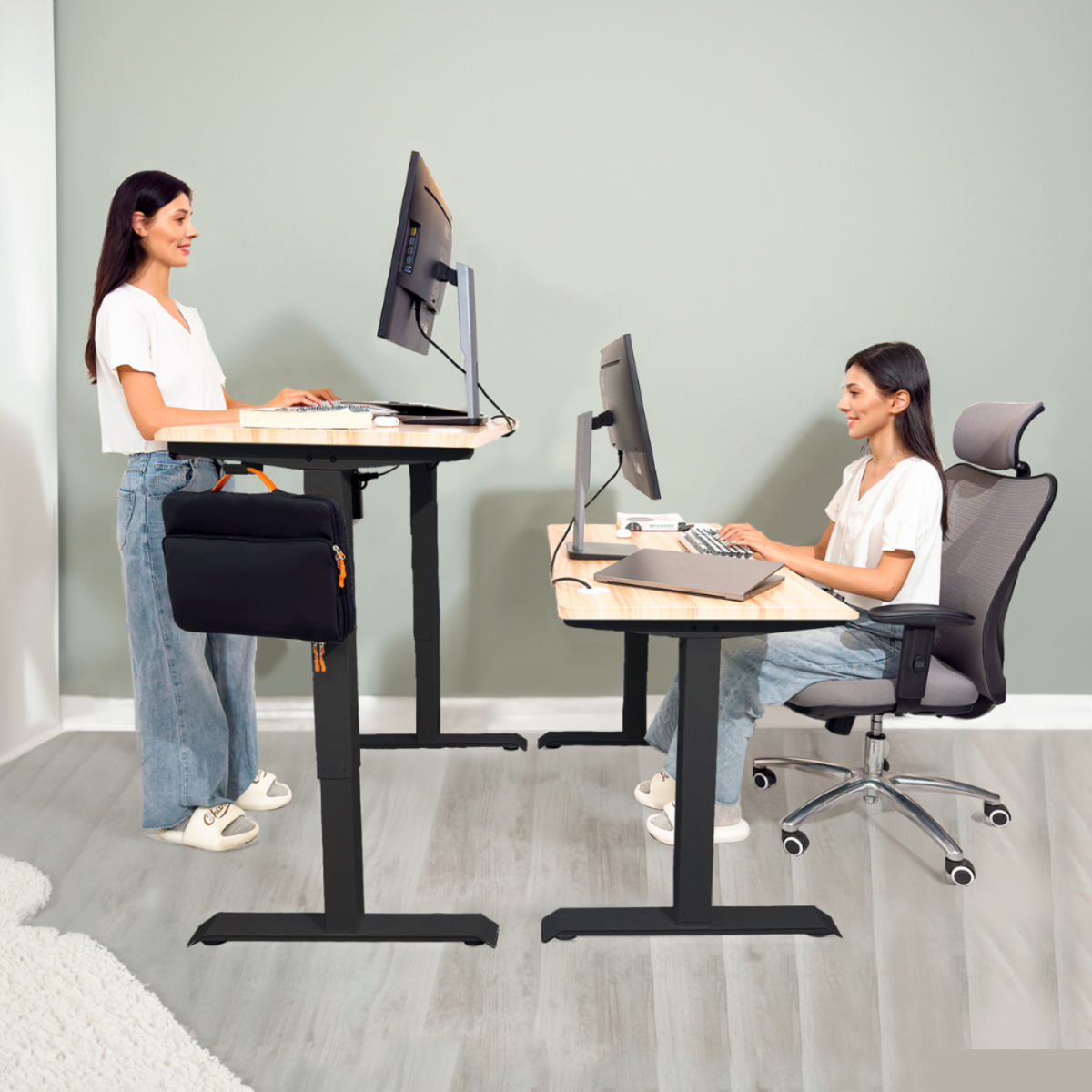 Dos mujeres trabajando en escritorios de altura ajustable, una de pie, la otra sentada, en una oficina moderna.