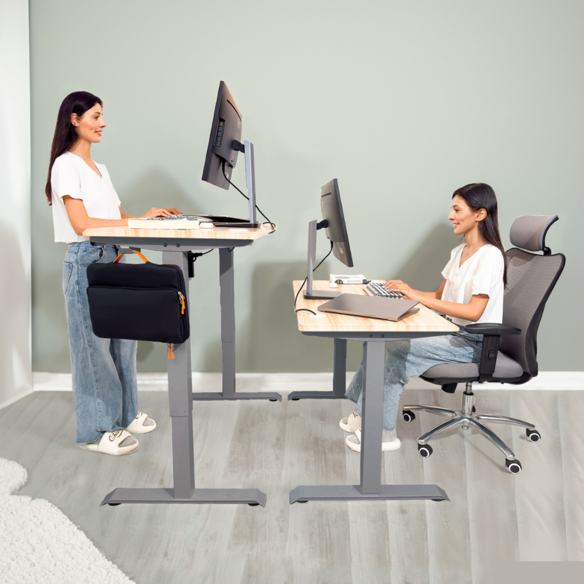 Dos mujeres en escritorios, trabajando en computadoras. Una de pie, otra sentada.