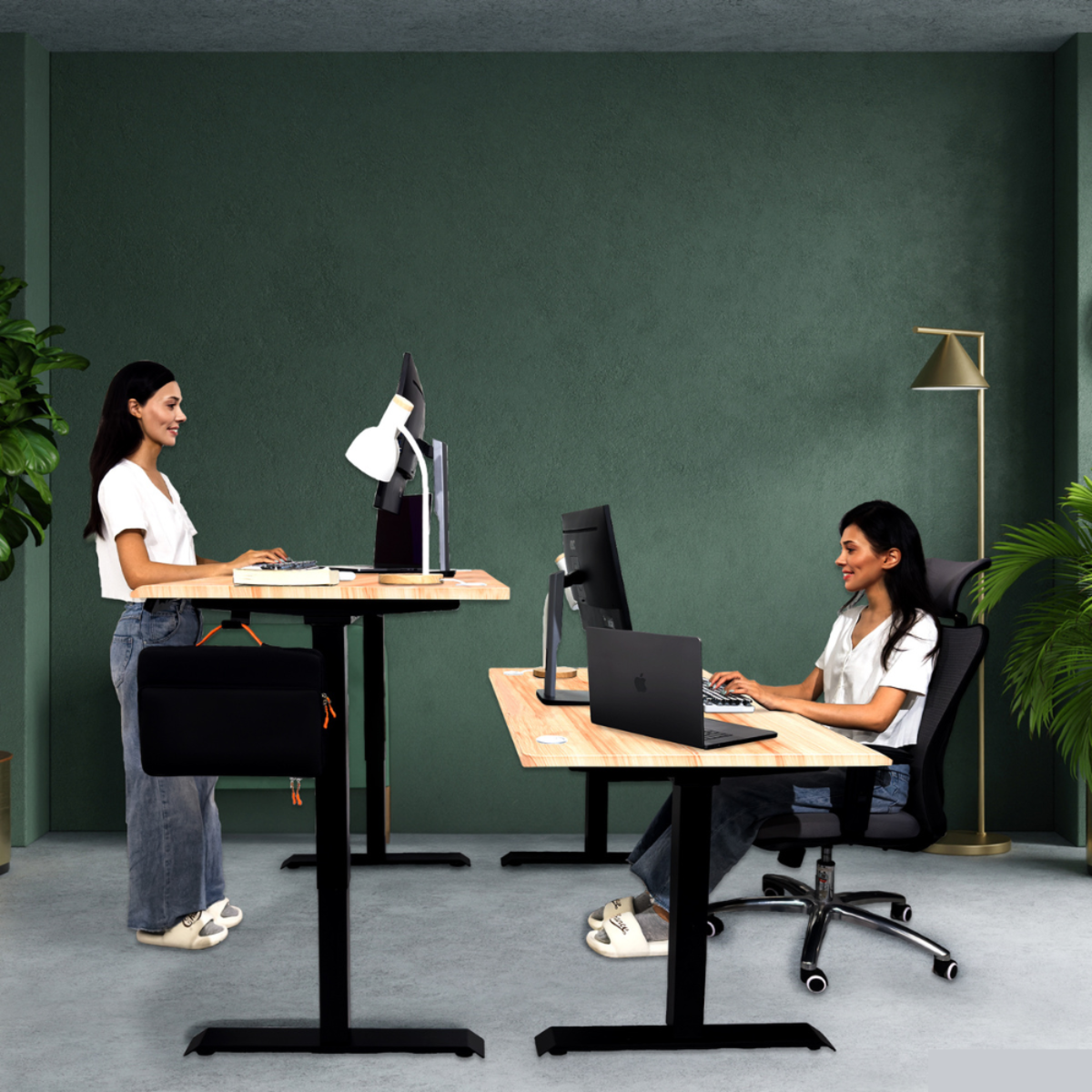 Dos mujeres en escritorios en una oficina moderna. Una de pie, la otra sentada.