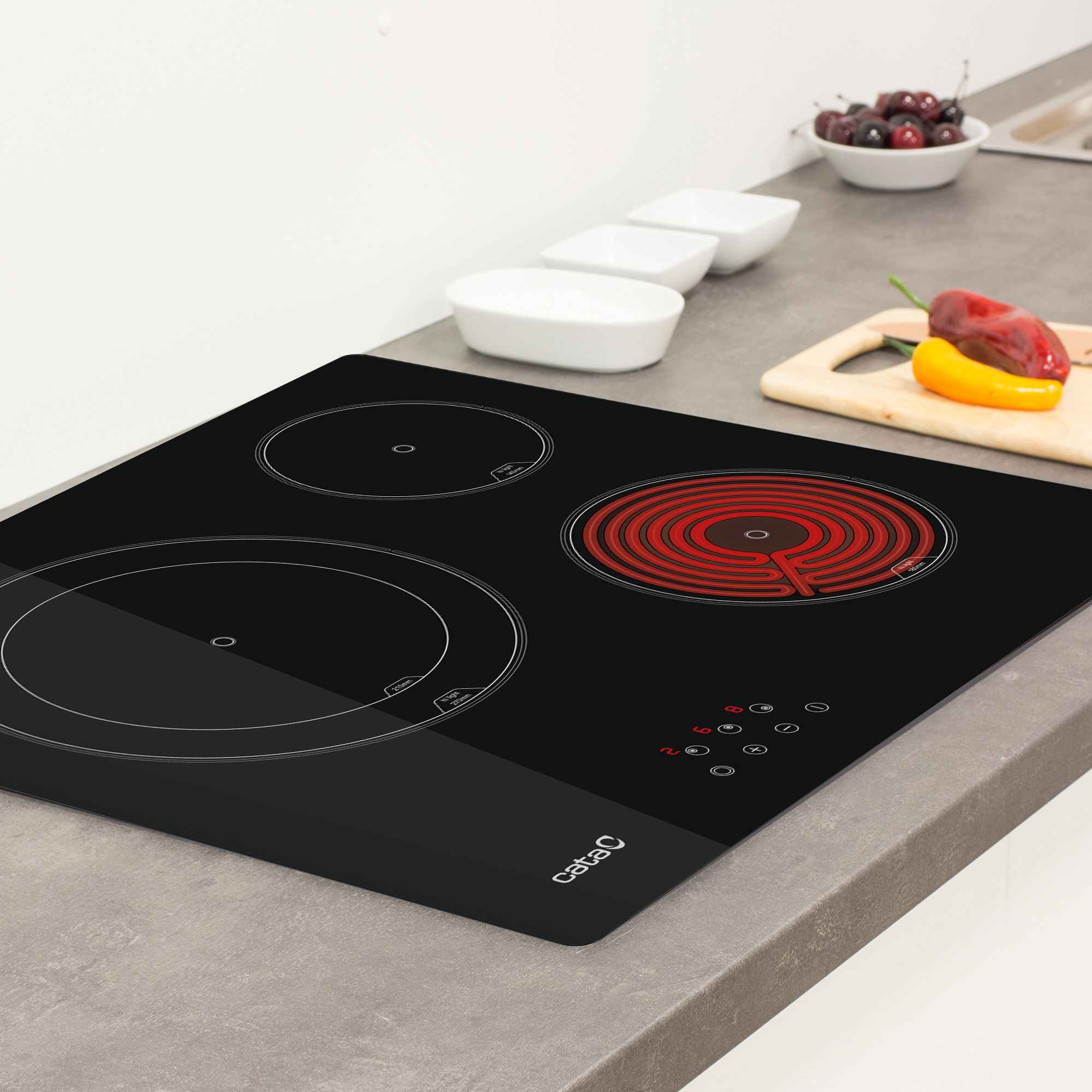 Piano cottura elettrico nero con tre zone cottura. Una è rossa e le altre sono cerchi neri.