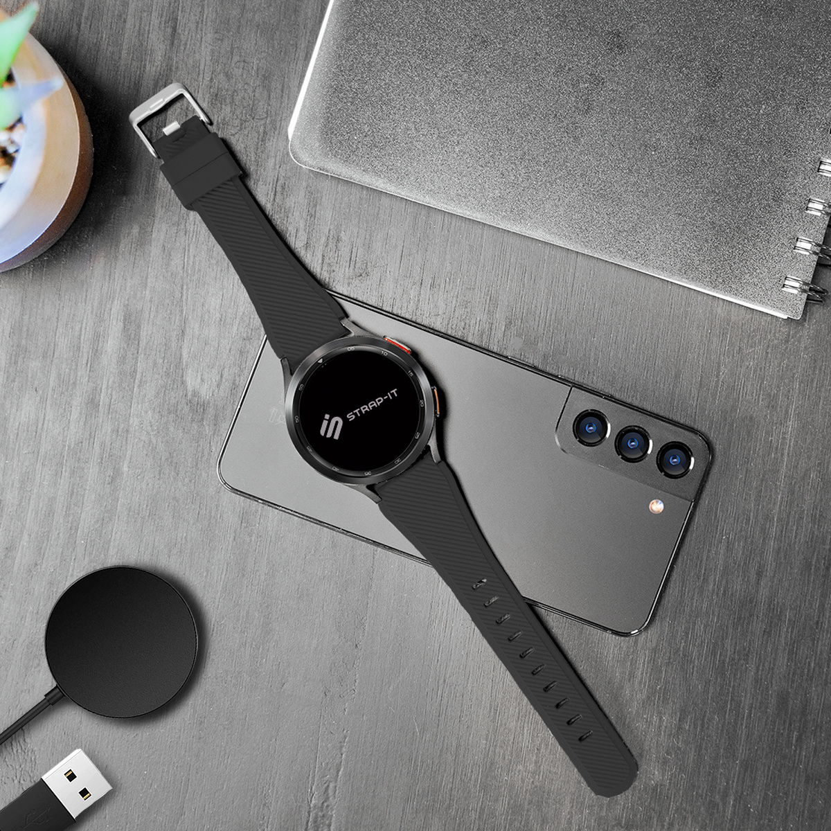 Smartwatch auf einem Telefon auf Holzoberfläche, mit Ladepad.
