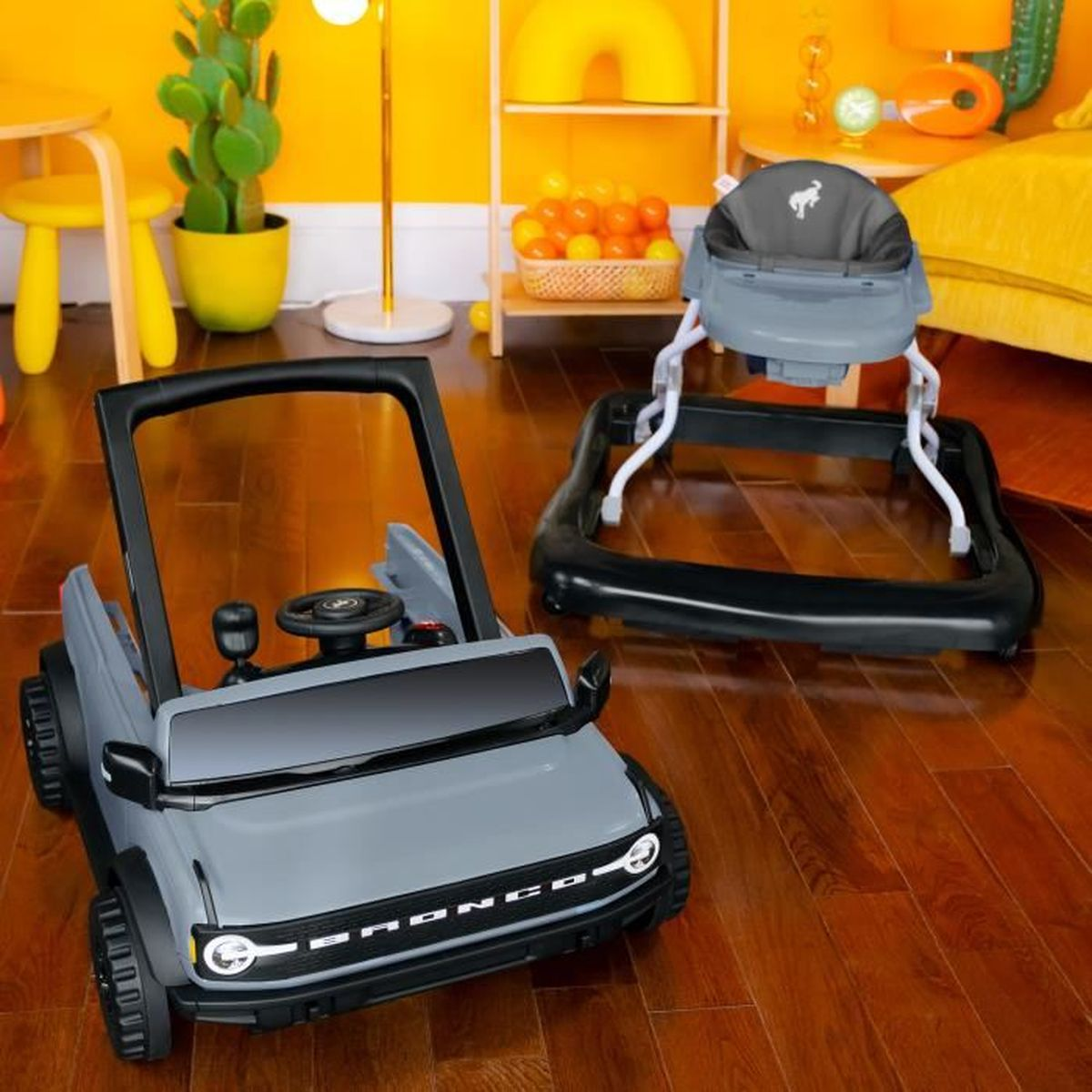 Spielzeugauto und Gehhilfe für Kinder sowie ein Bällebad. Gelber und oranger Hintergrund.