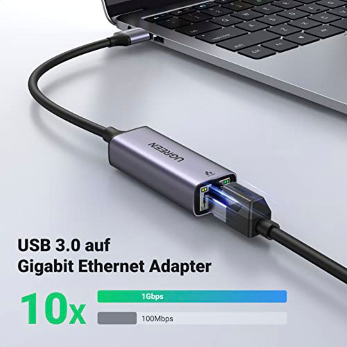 Bir dizüstü bilgisayara bağlı gri bir USB 3.0 - Gigabit Ethernet adaptörü. Adaptörün siyah bir kablosu var.