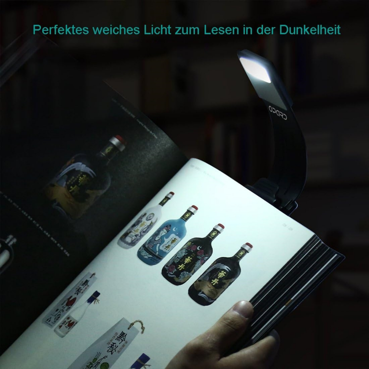 Ein Buch mit angebrachter Leseleuchte, die eine Seite mit Flaschen beleuchtet.