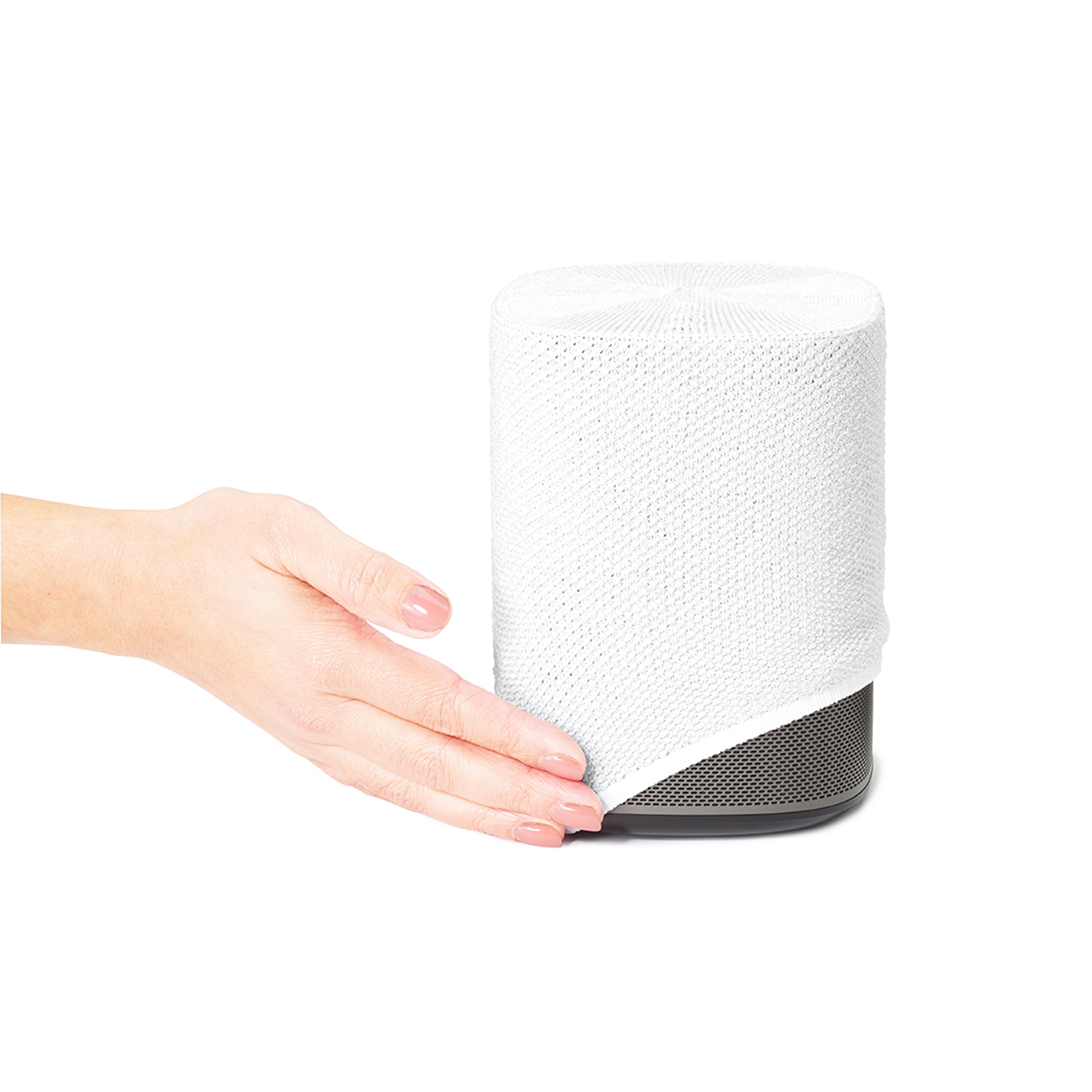 Un haut-parleur blanc avec une housse en tissu blanc, et la main d'une personne qui l'atteint.