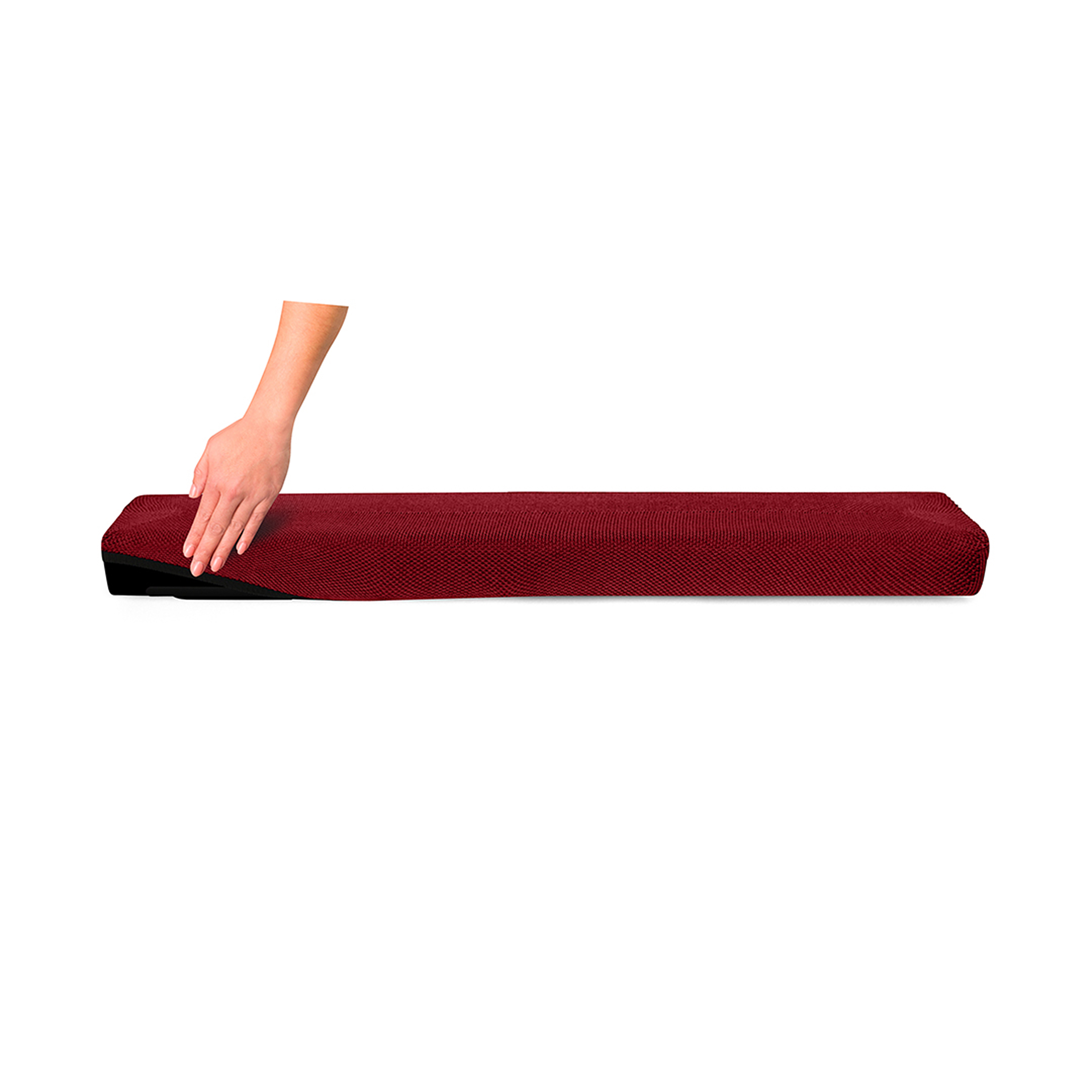 Une main touche un tapis de yoga enroulé, de couleur bordeaux, sur fond blanc.