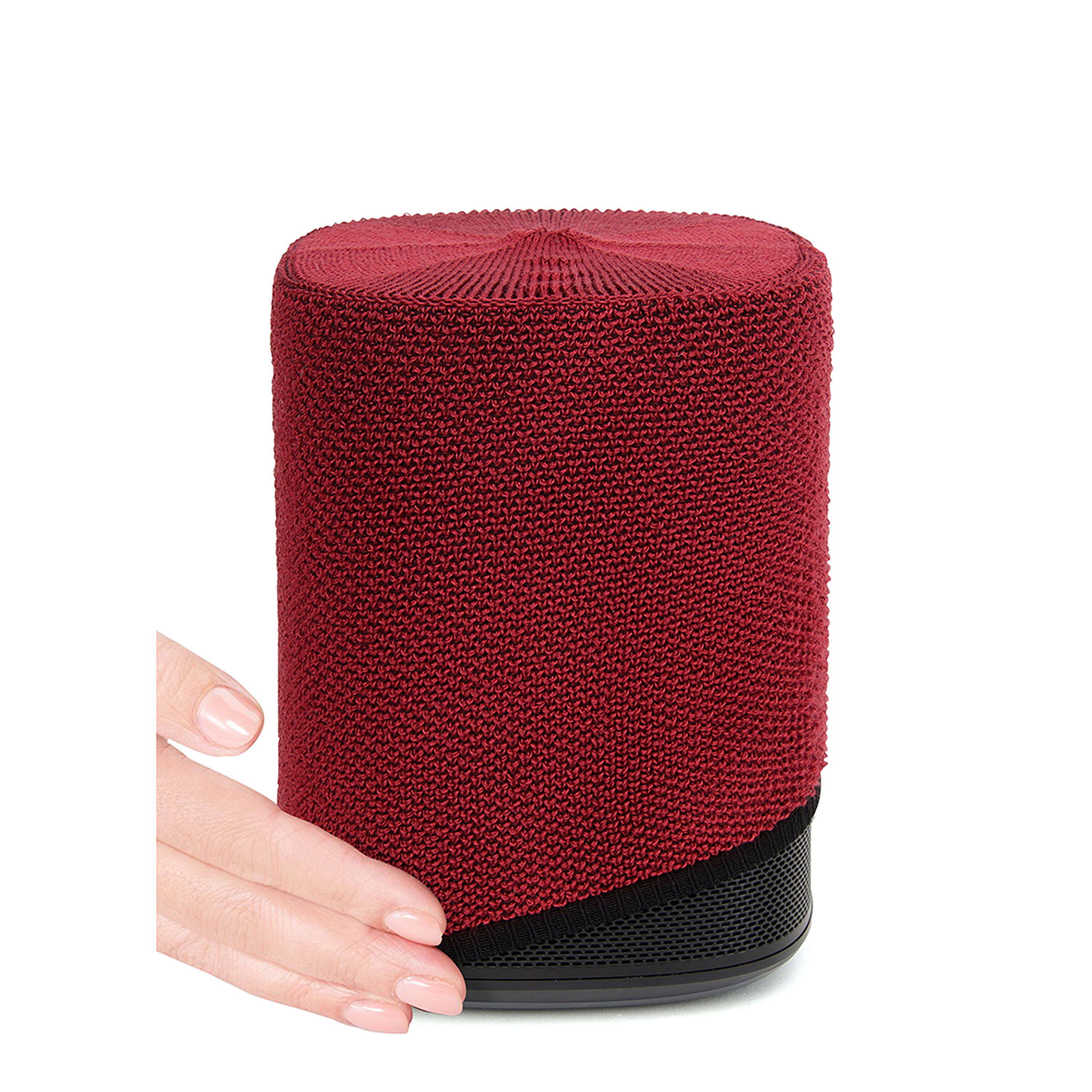 Haut-parleur rouge tricoté avec base noire. Une main touche le haut-parleur.