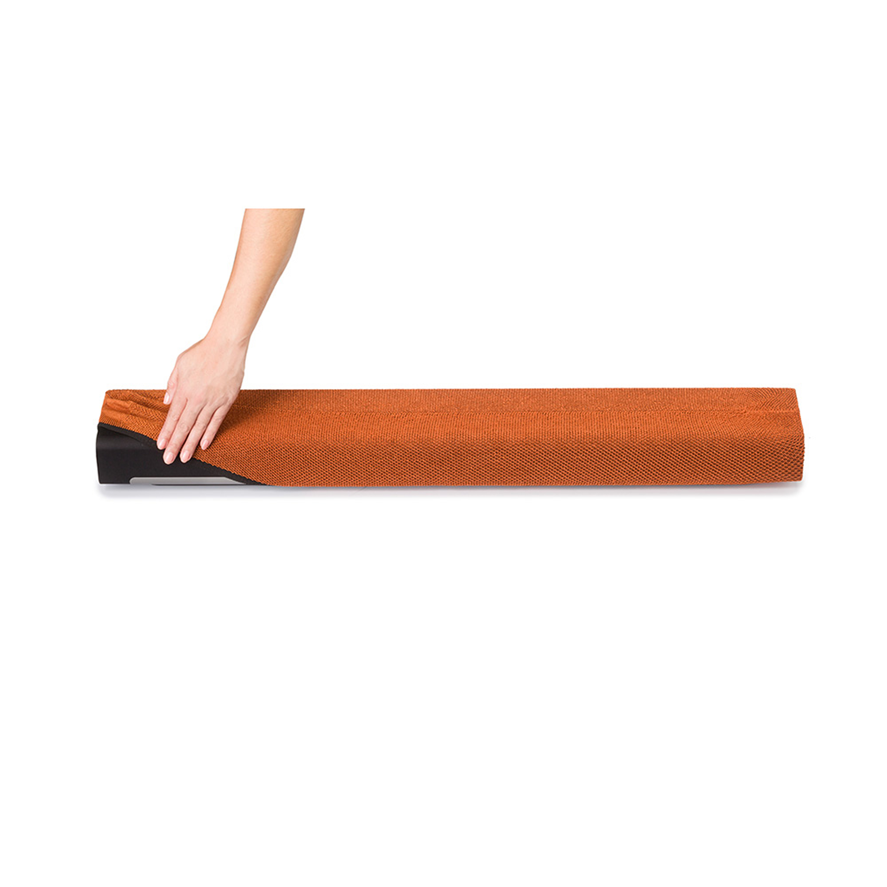 Une main enroulant un tapis en tissu orange sur fond blanc.