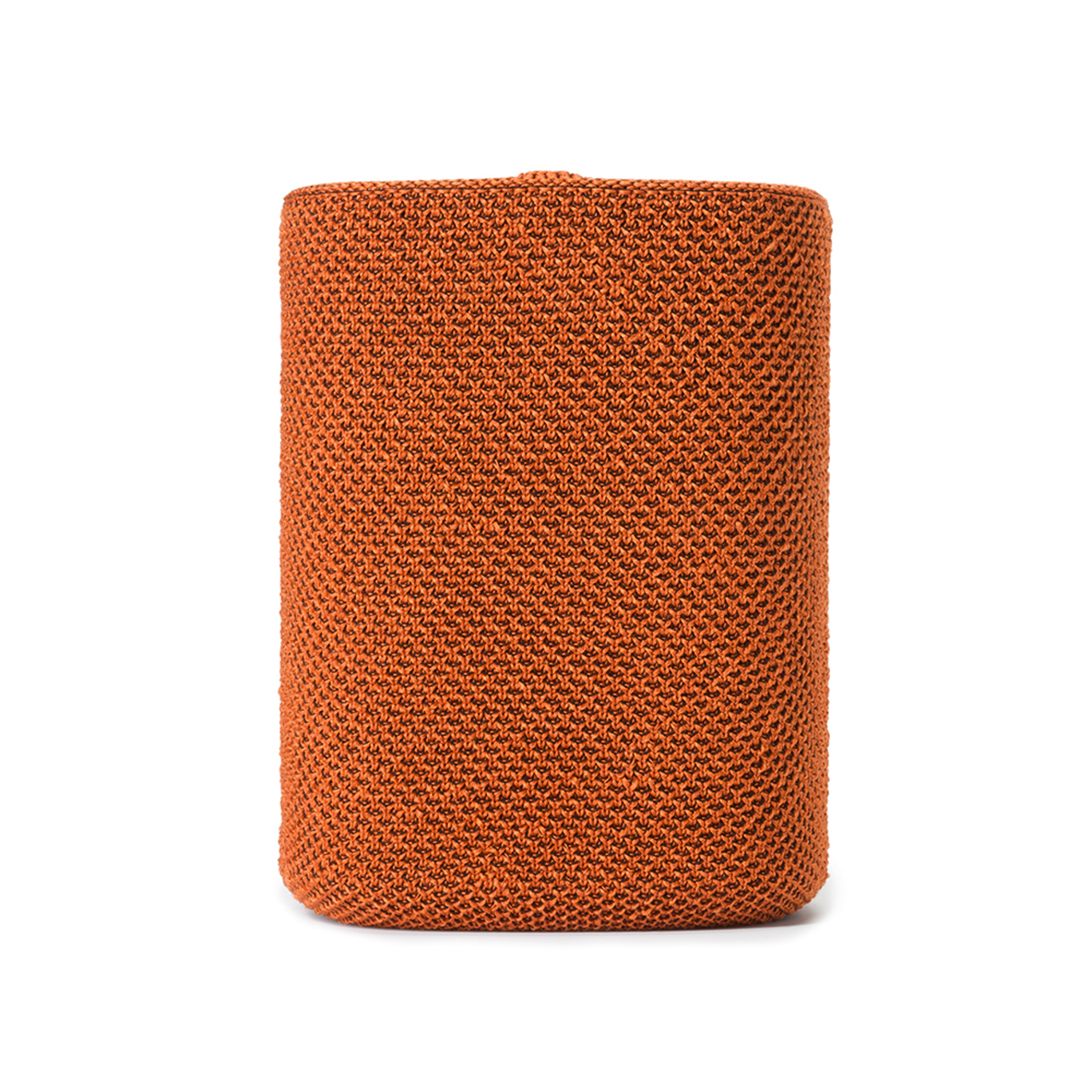 Cylindre en tricot orange sur blanc. La texture est visible. Il est debout.