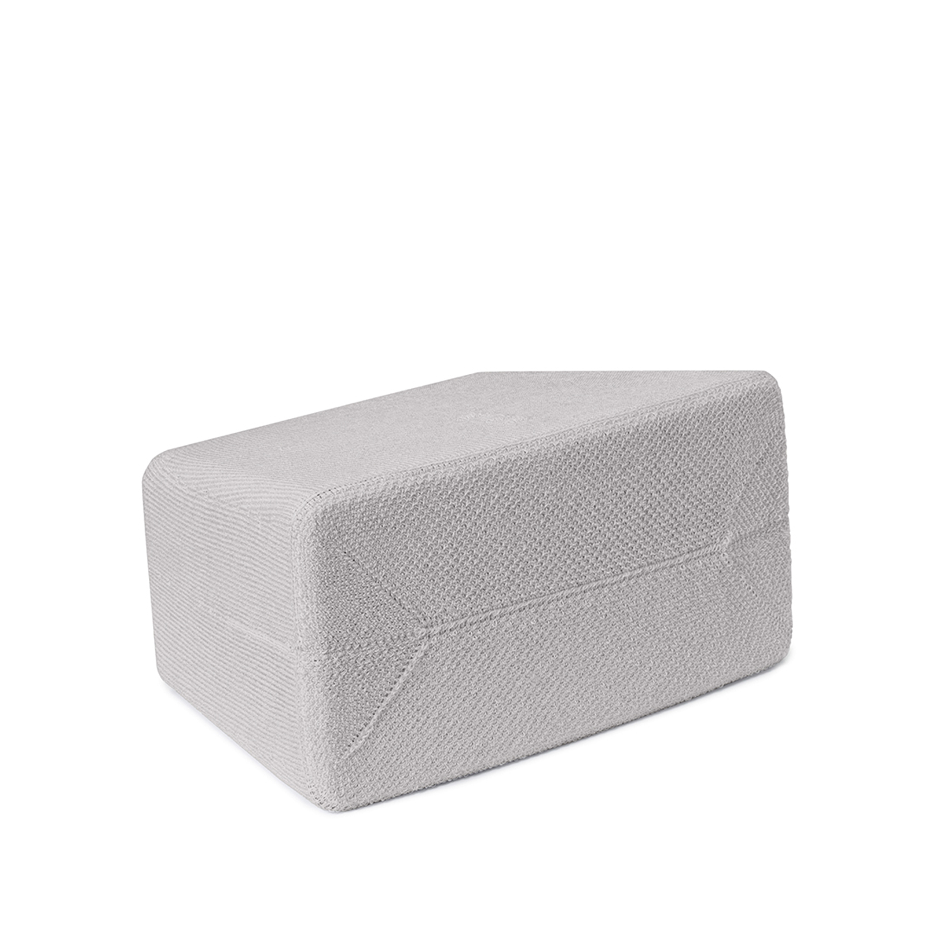 Un bloc de yoga gris. Il est rectangulaire, avec des bords arrondis, sur fond blanc.