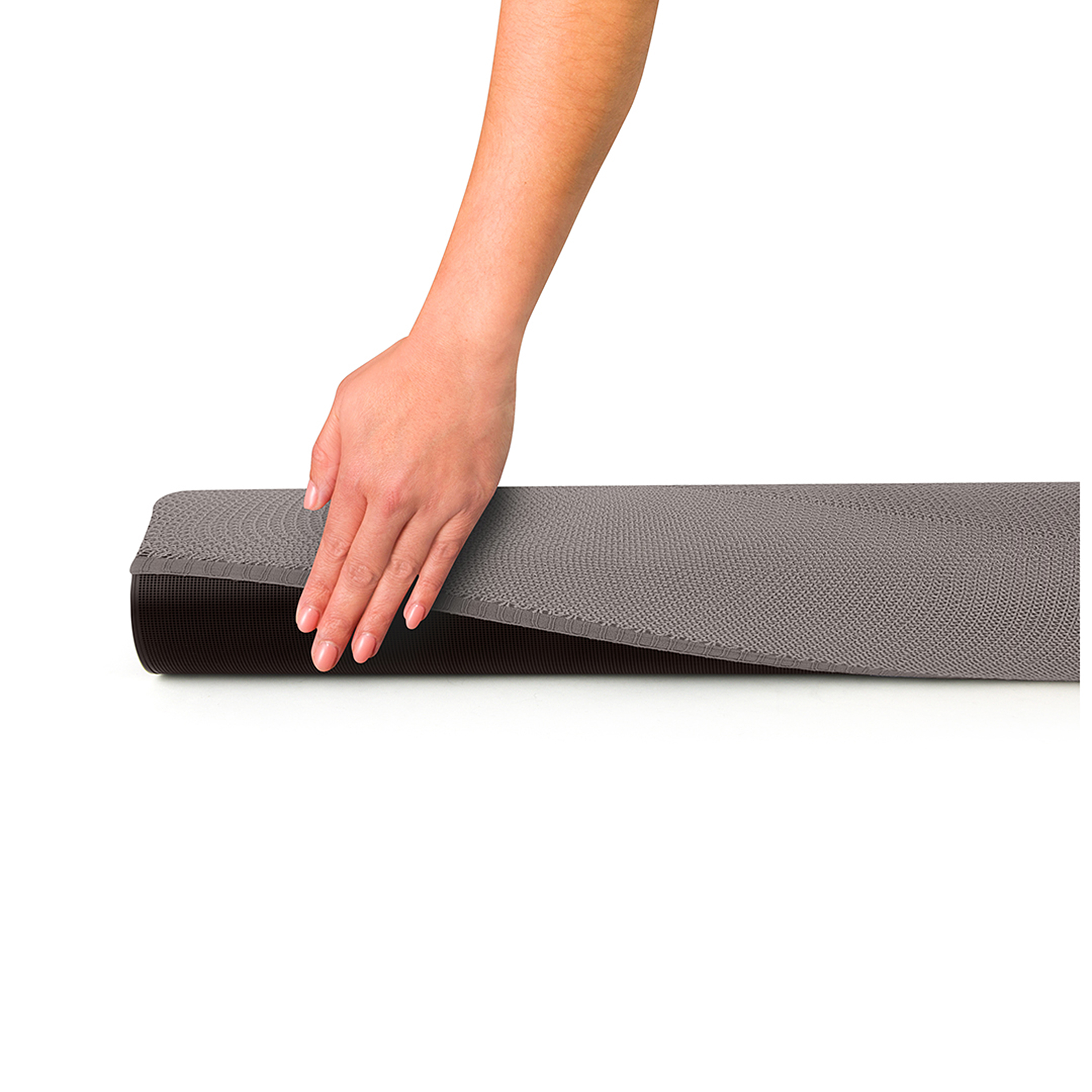 Een hand die een grijze yogamat oprolt. Zwarte onderkant, witte achtergrond.