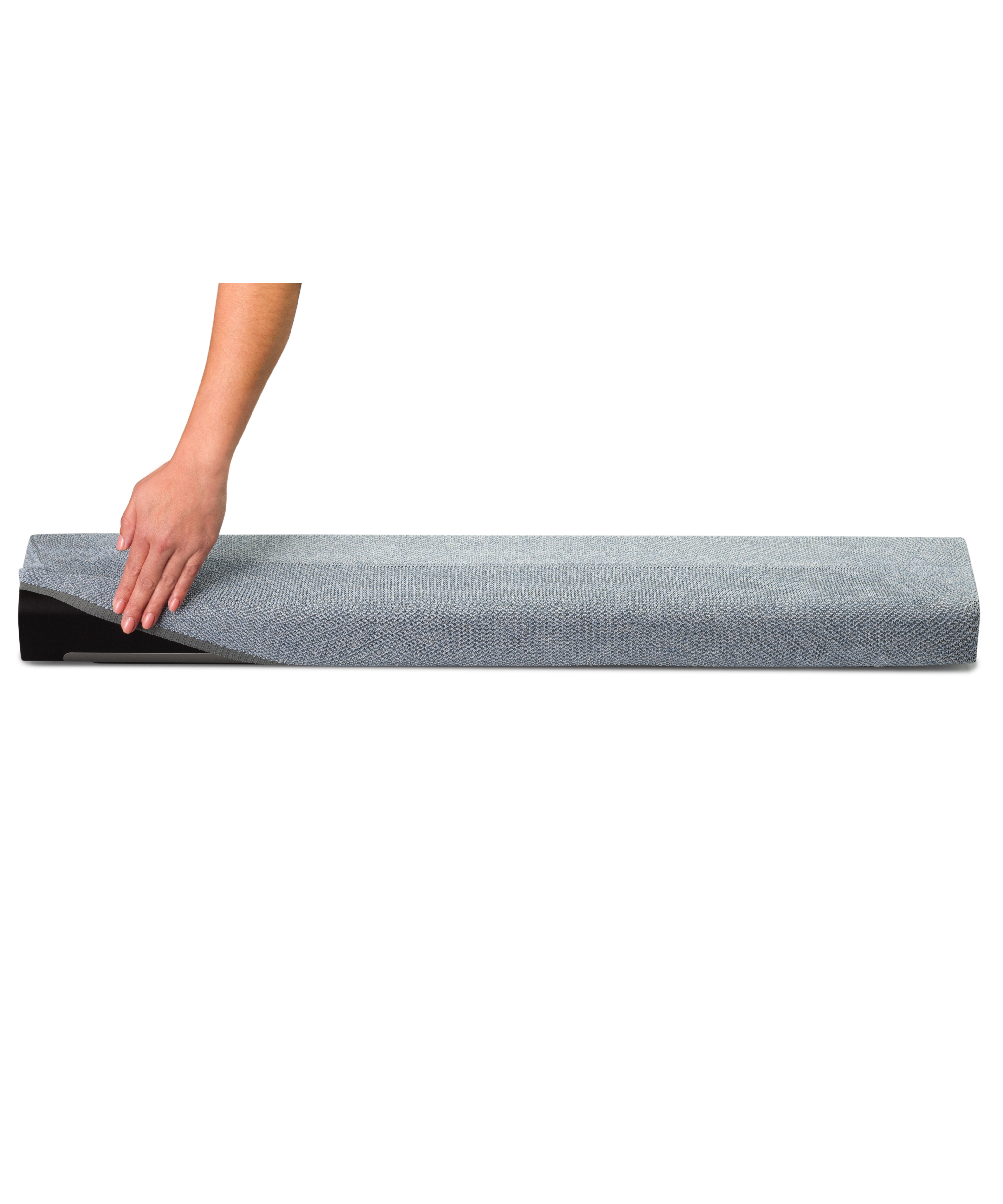 La main d'une personne lissant une housse en tissu gris.