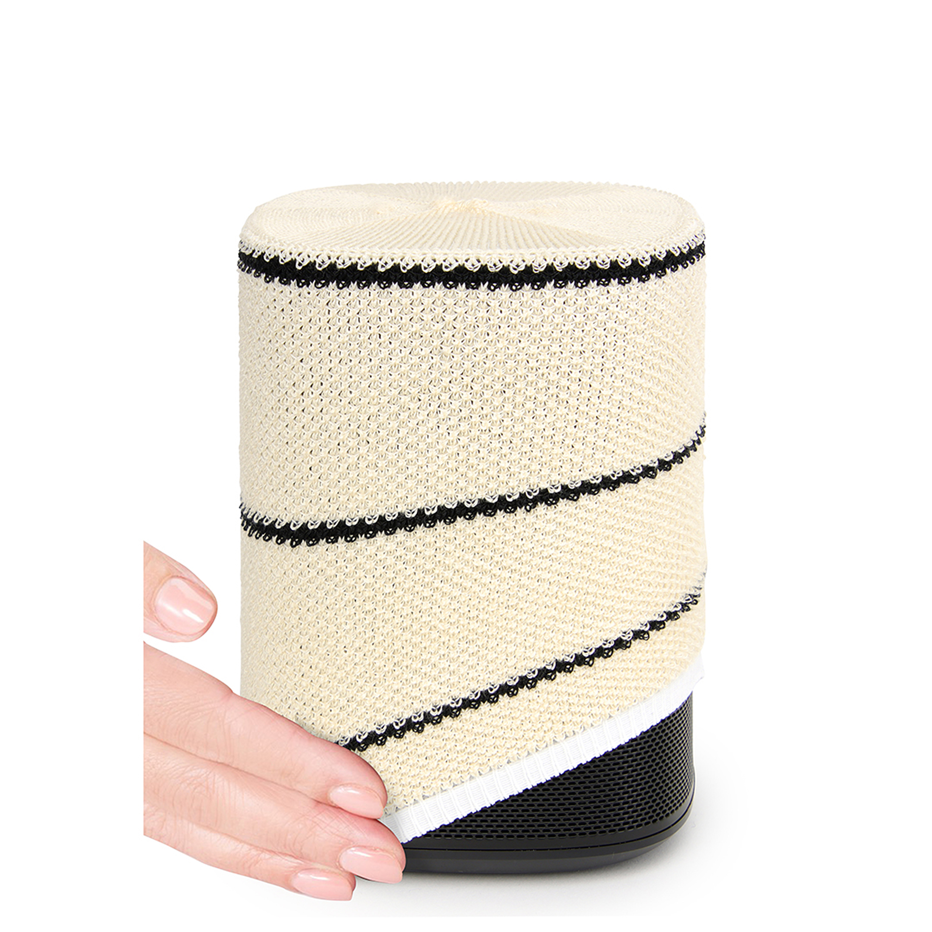 Un haut-parleur beige avec des rayures et une base noires. Une main touche le haut-parleur.