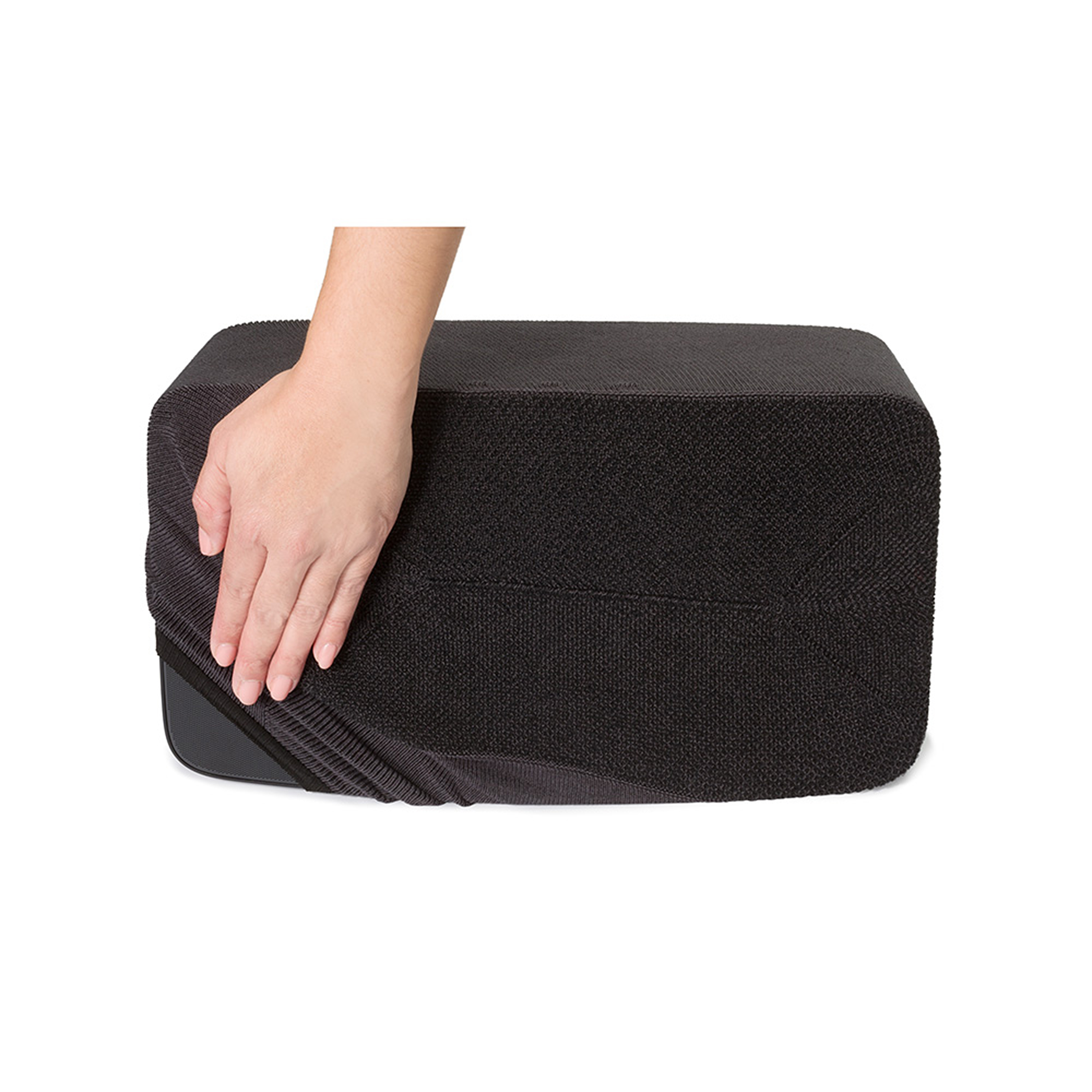 Une main recouvrant un haut-parleur noir avec une housse en tricot noir, sur fond blanc.