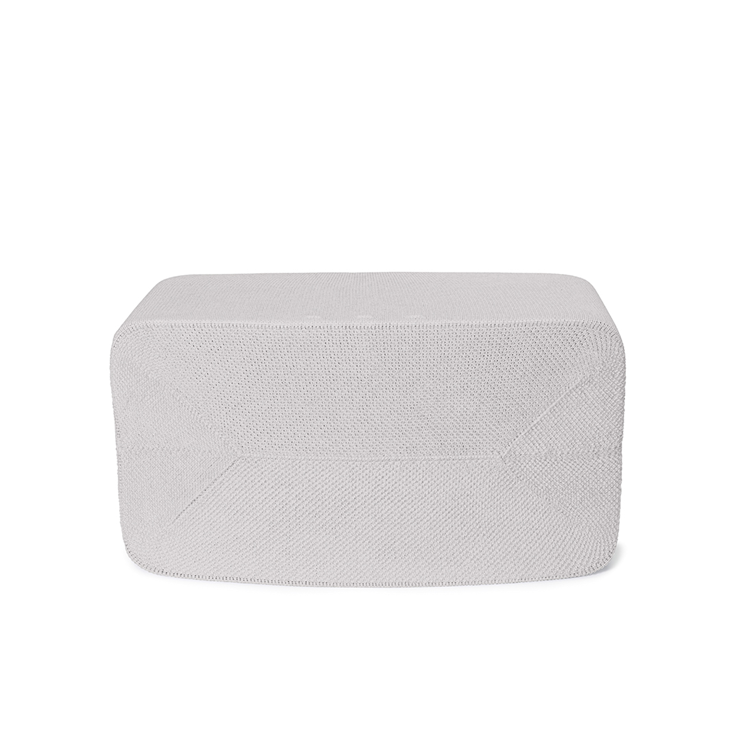 Un pouf blanc tricoté sur fond blanc. Le dessus est plat.