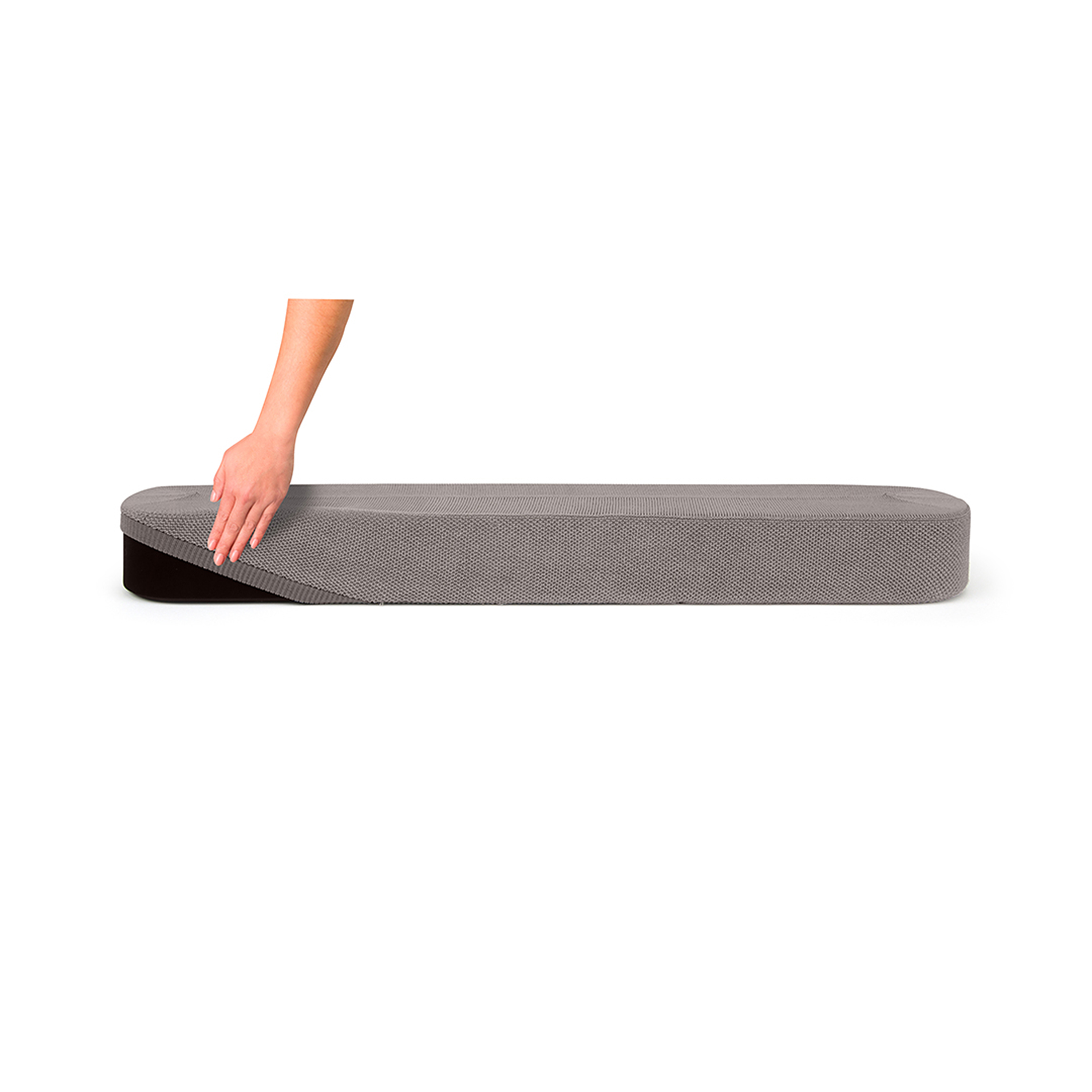 Main couvrant partiellement un step de fitness en mousse grise et noire, fond blanc.