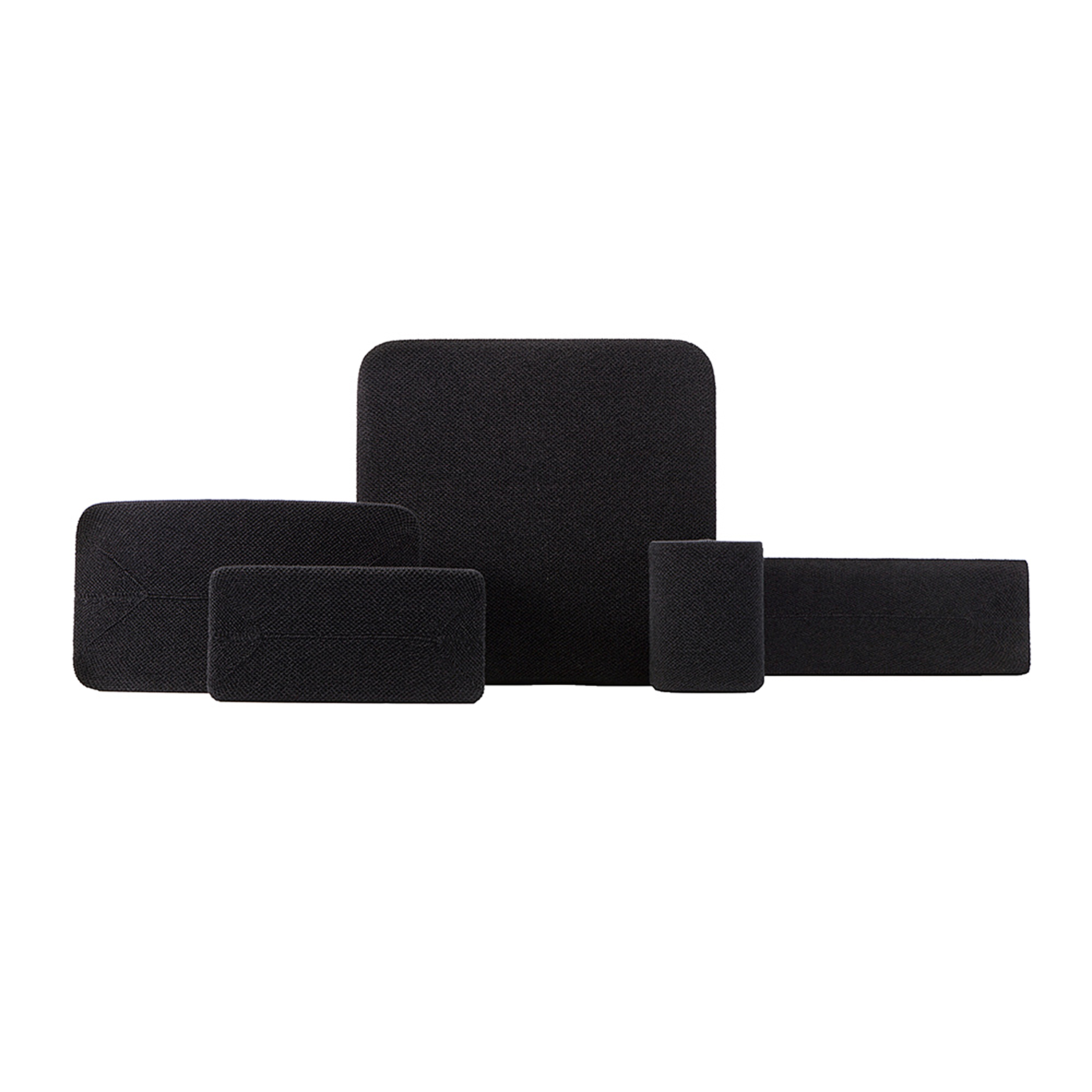 Un ensemble de cinq coussins noirs texturés sur fond blanc.