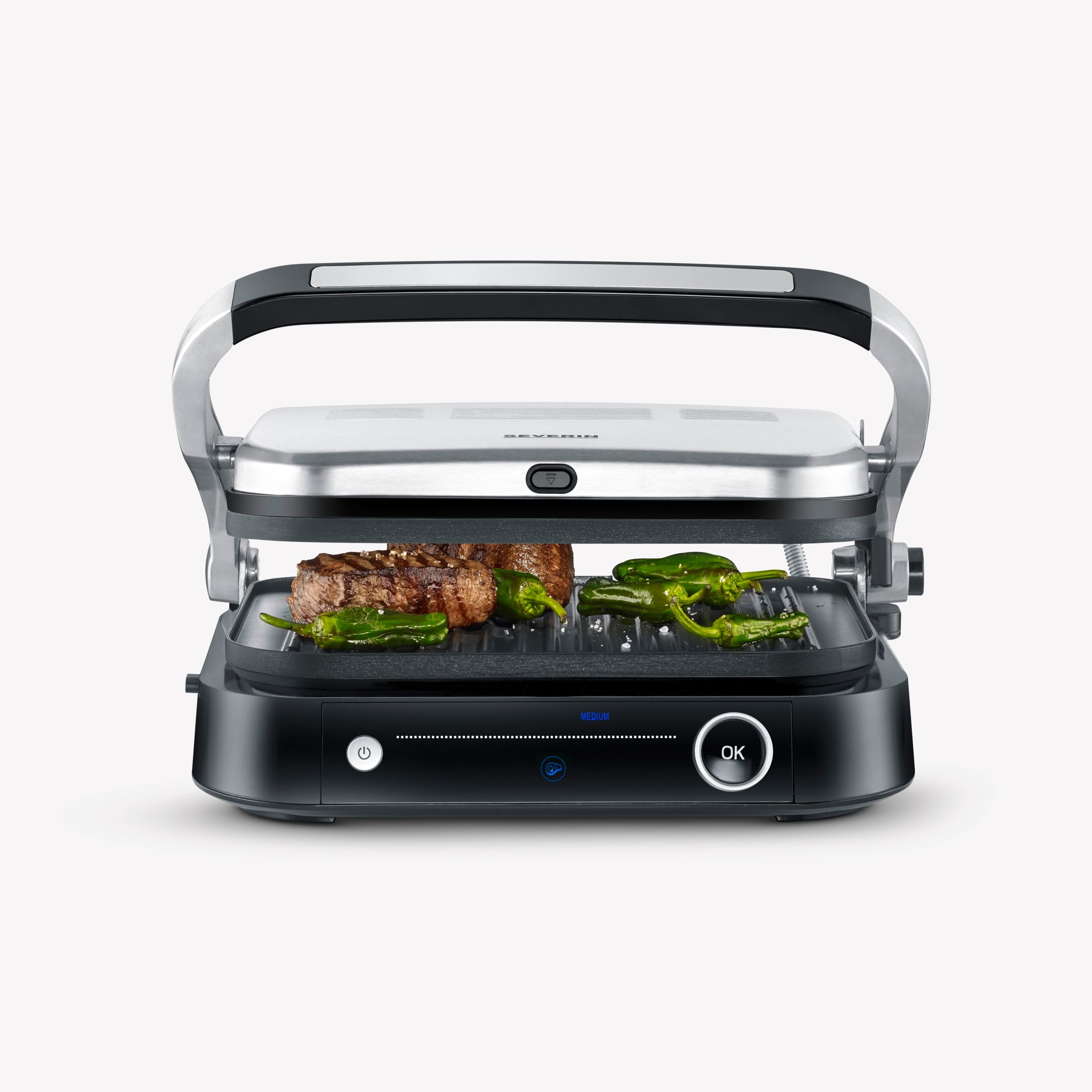 Een grill met een biefstuk en groene paprika's erin. De grill is zwart en zilver met een OK-knop.