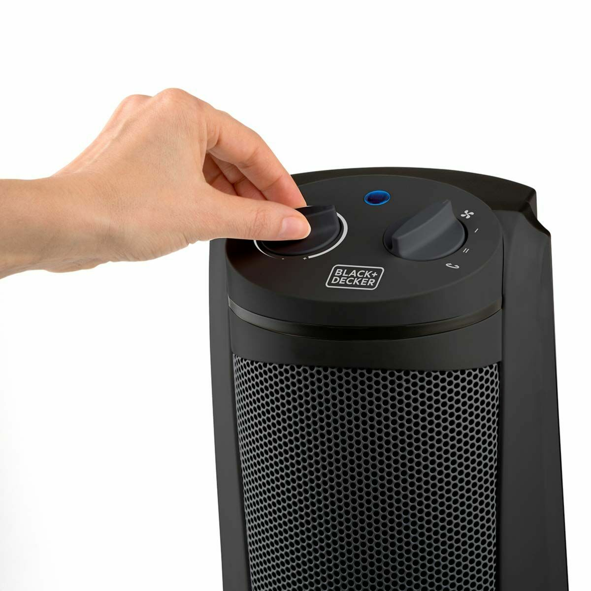 Dłoń obracająca pokrętło na czarnym grzejniku.