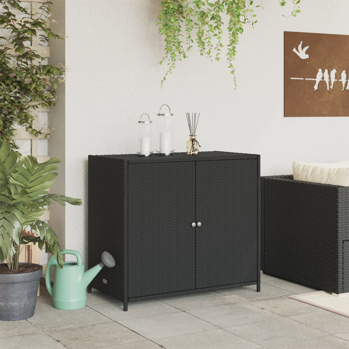 Schwarzer Weidenholzschrank in einer Terrasse mit Pflanzen und Dekoration.