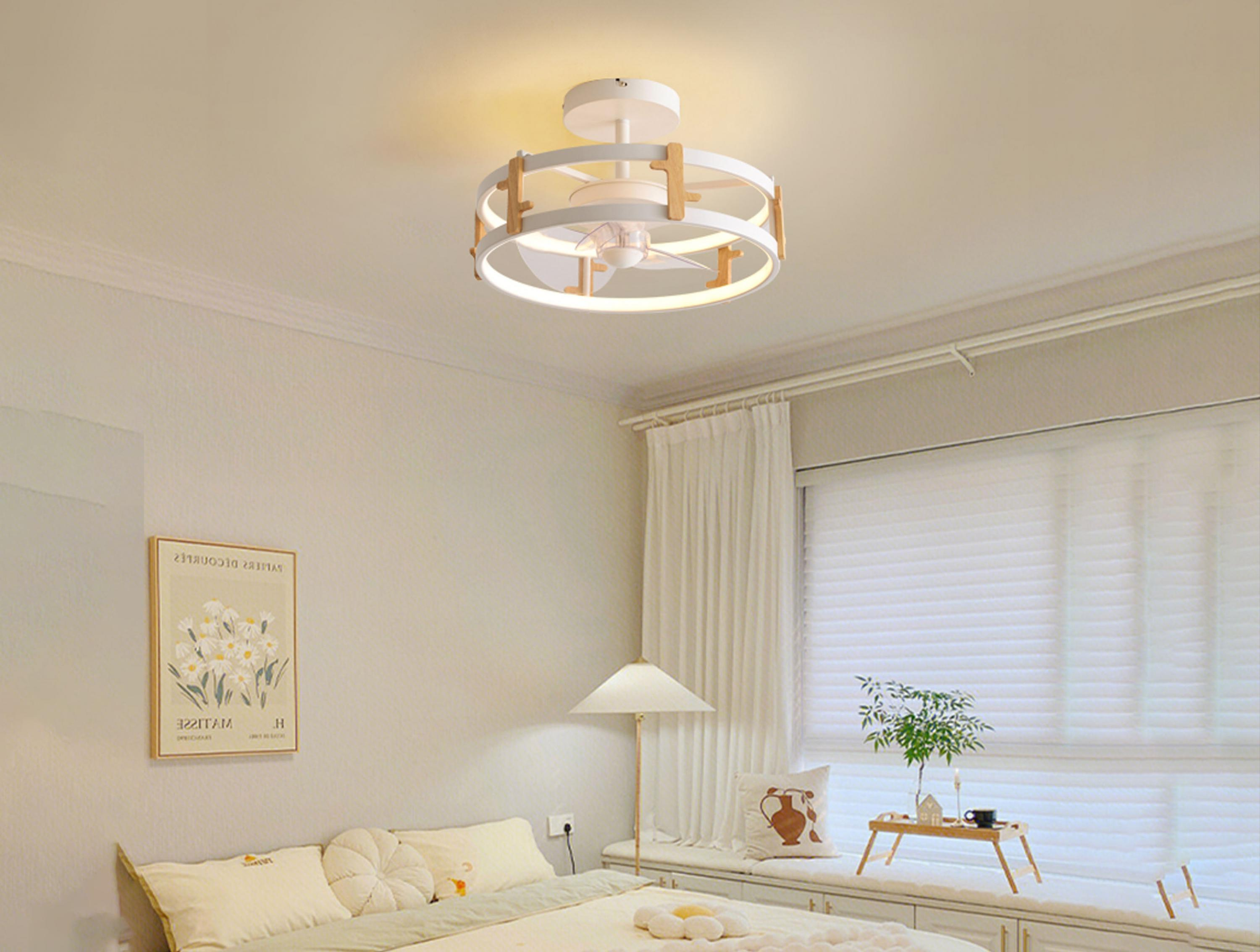 Ein Deckenventilator mit Licht hängt in einem Raum mit einem Bett.