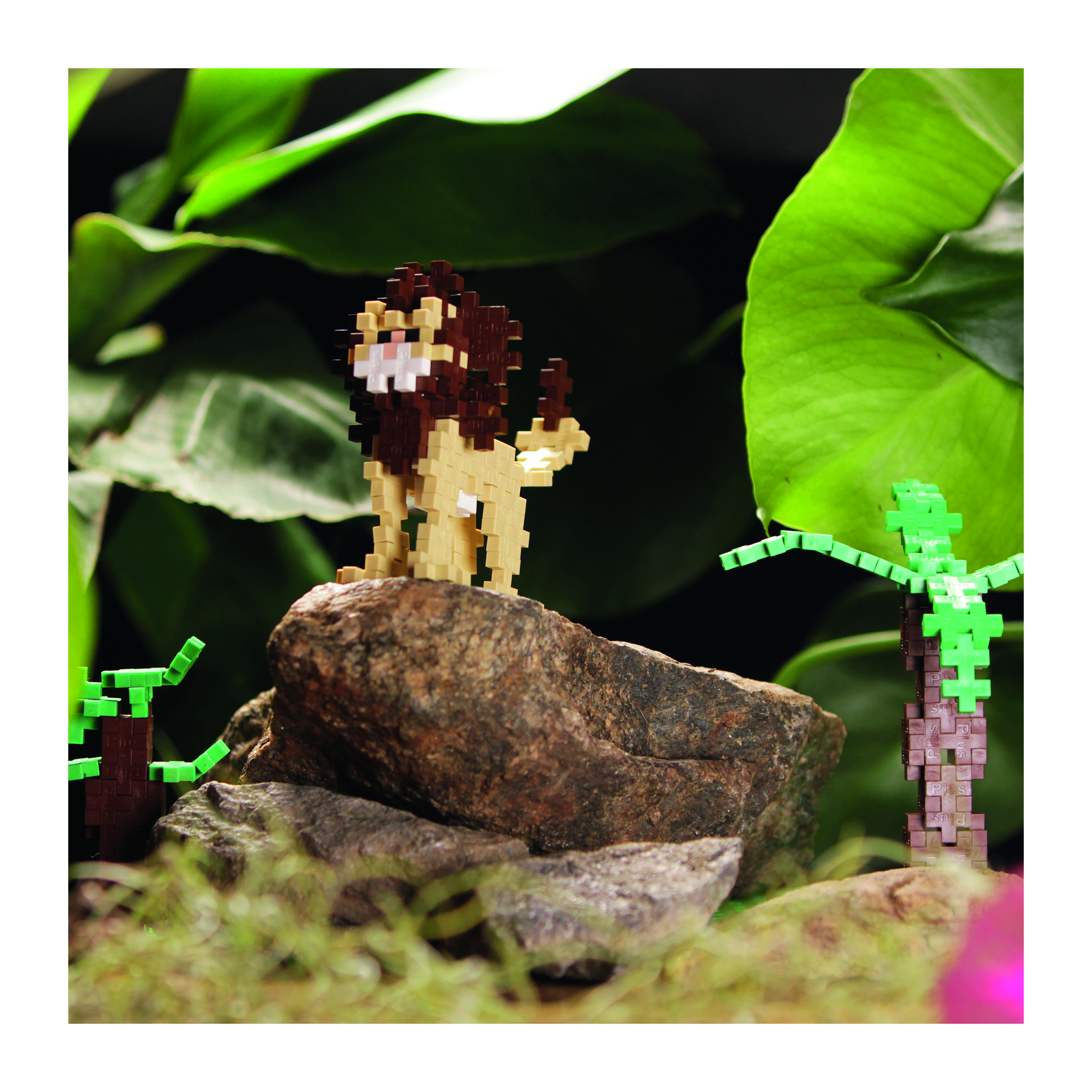 Ein Löwe aus Spielzeugsteinen steht auf einem Felsen, mit grünen Spielzeugbäumen.