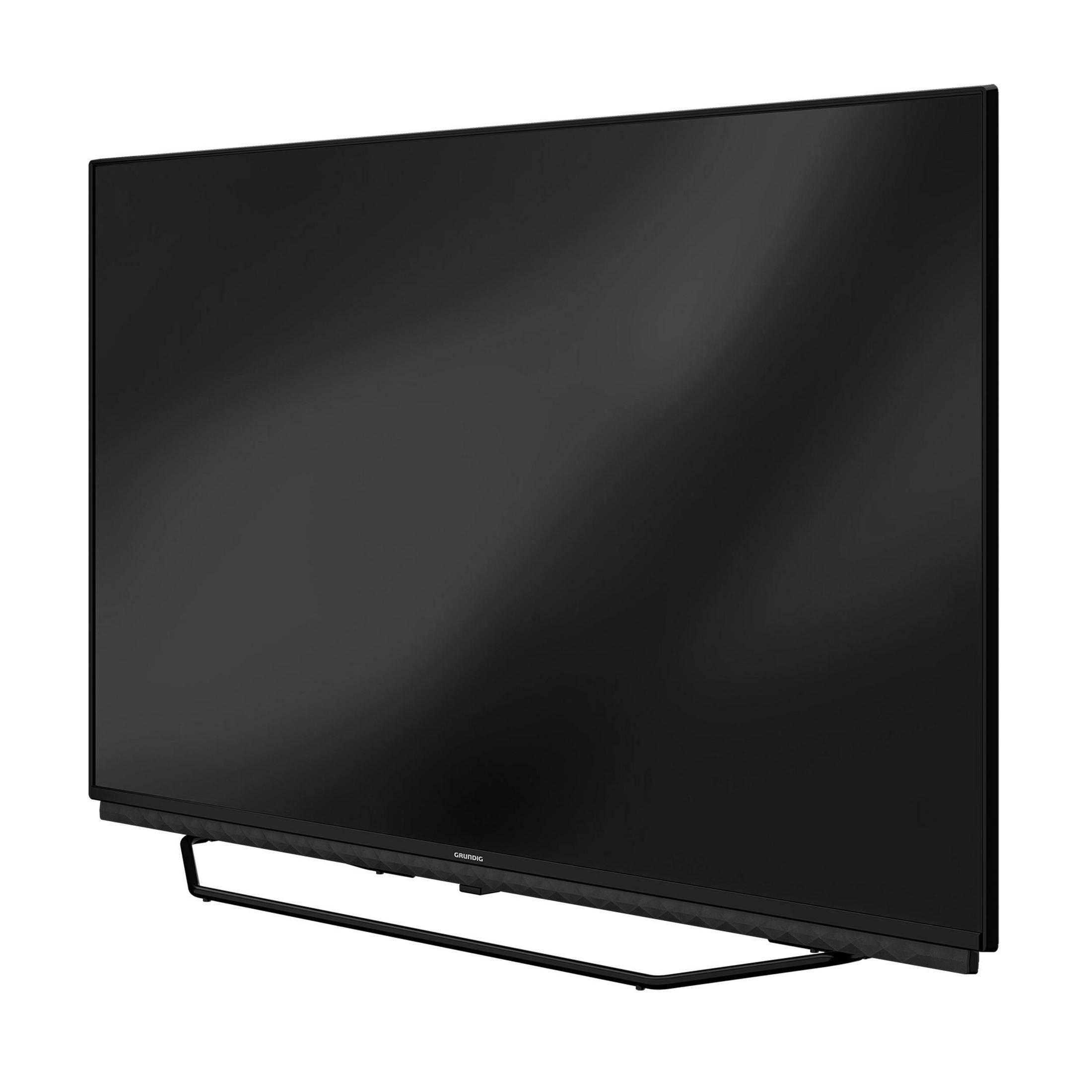 Téléviseur à écran plat noir sur un support. Le logo GRUNDIG est visible sur le cadre.