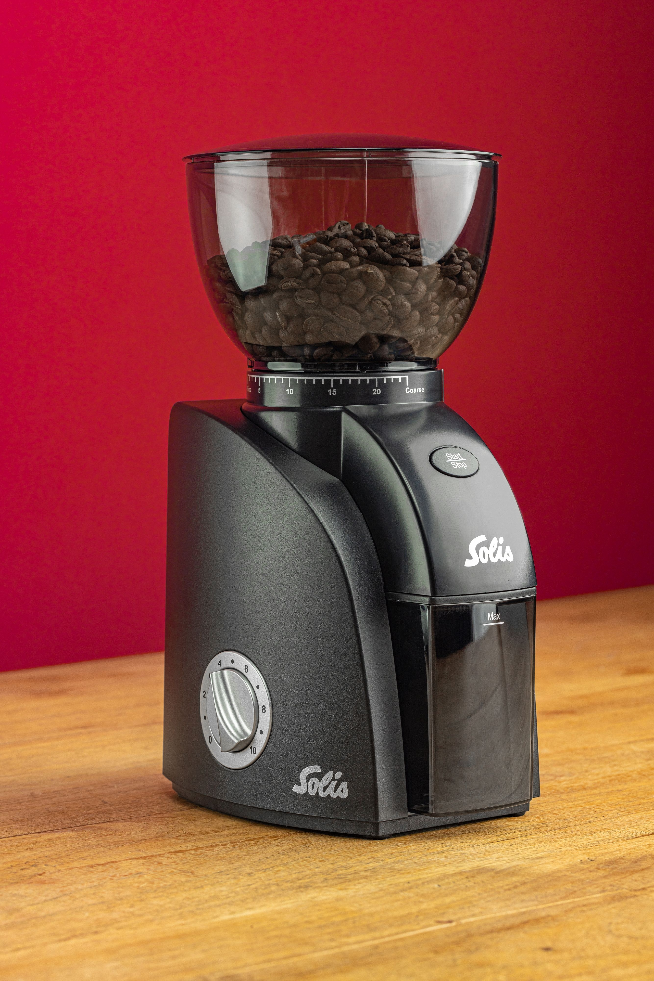 Czarny młynek do kawy Solis z ziarnami w przezroczystym pojemniku.