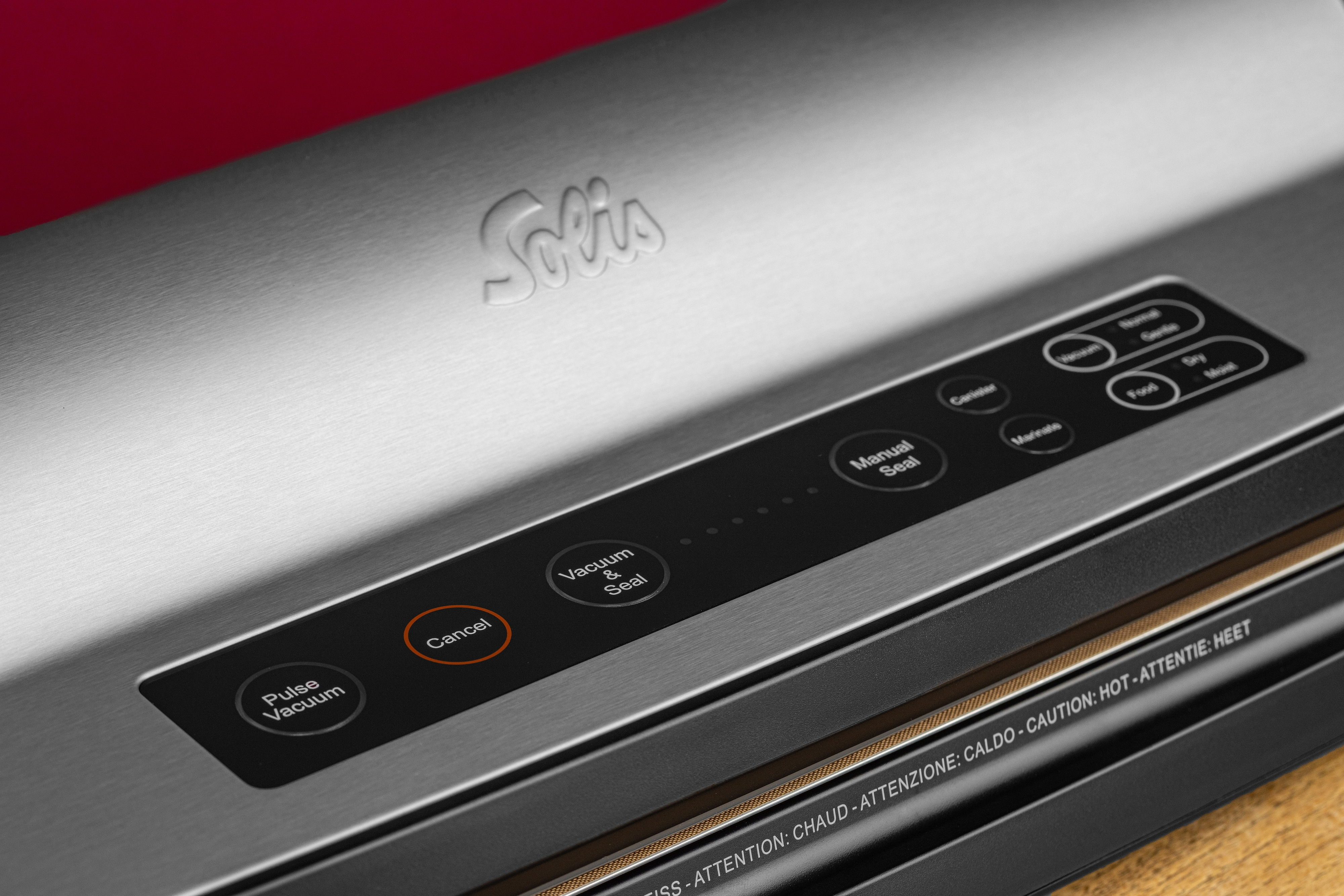 Zbliżenie maszyny do zgrzewania próżniowego z przyciskami i nazwą marki.