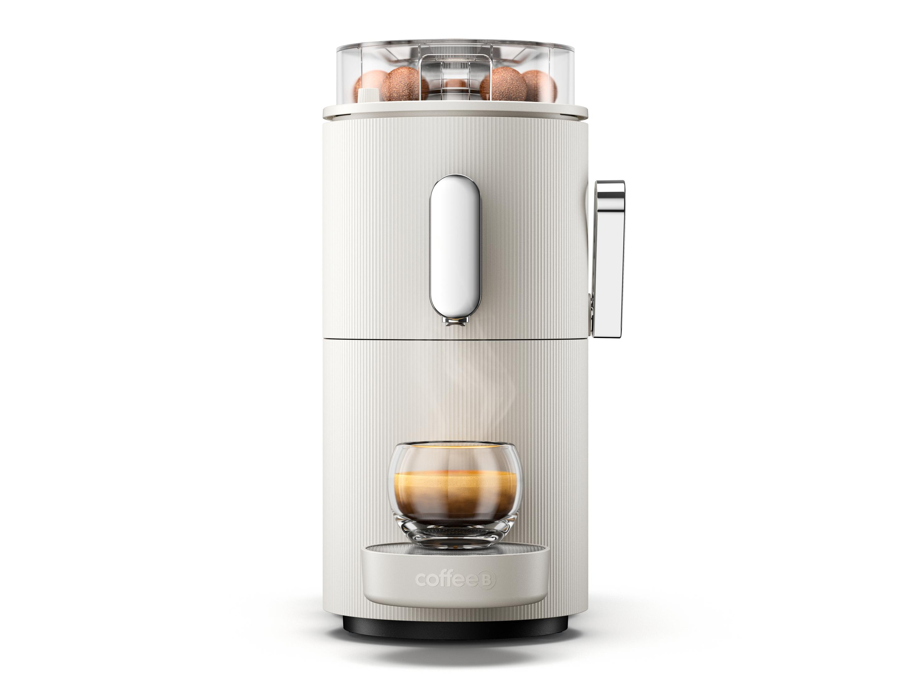 Weiße Kaffeemaschine mit Glasbecher und Dampf darunter. Sie hat eine Oberseite mit braunen Kaffeebohnen.