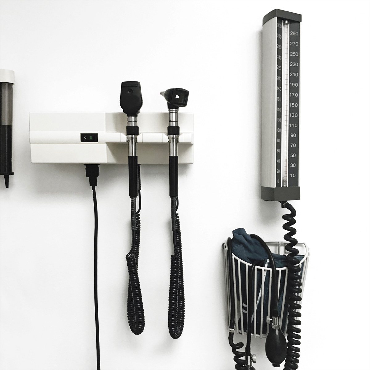 Medische apparatuur op een witte muur. Inclusief een bloeddrukmeter en medische lampen.