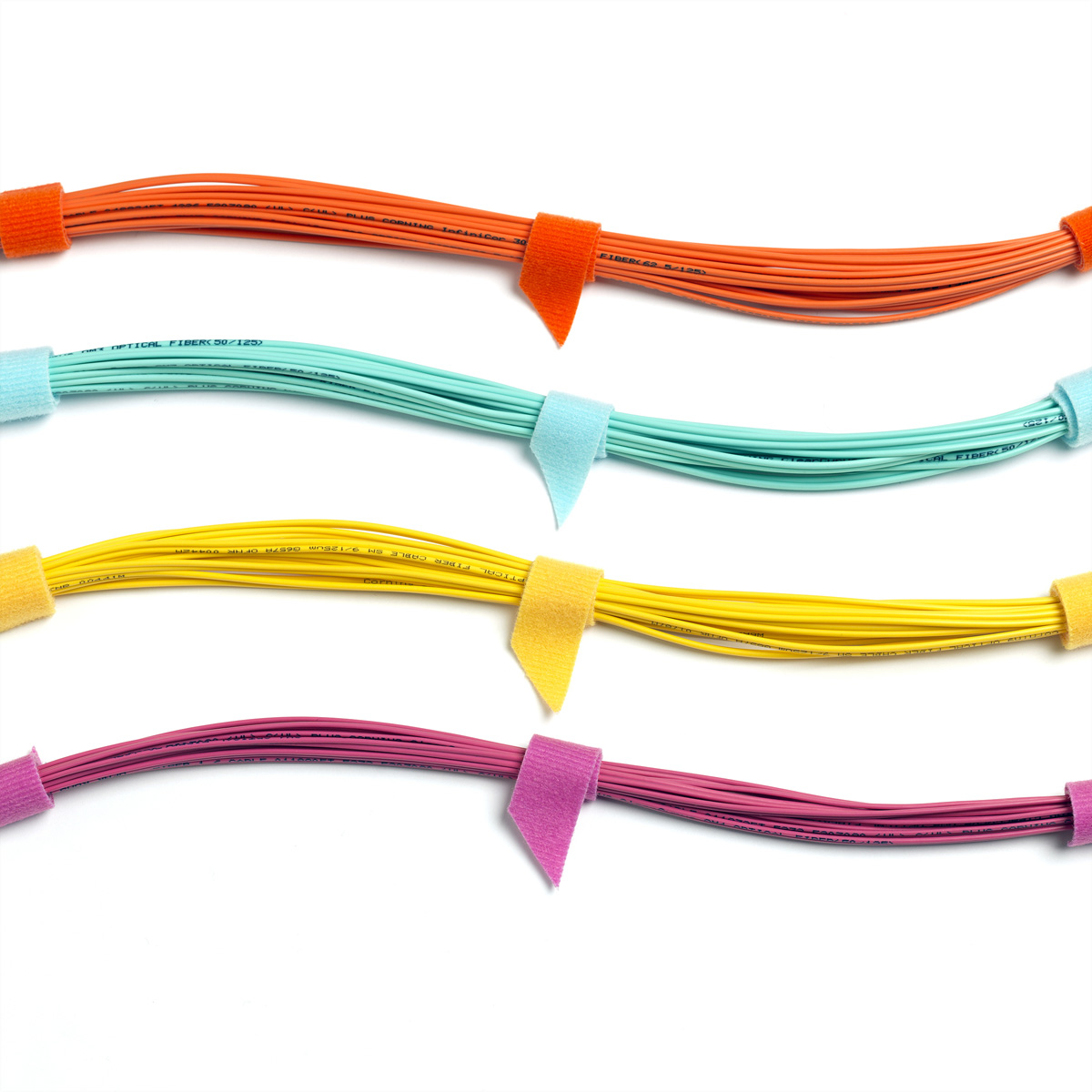 Cinque cavi in fibra ottica colorati con cinghie in velcro colorate: arancione, azzurro, giallo, rosa e viola.