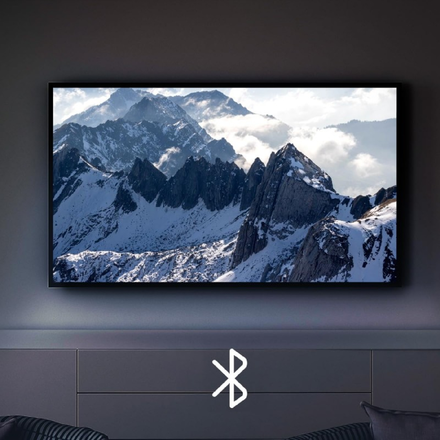 Schermo TV con montagne innevate. Logo Bluetooth in basso.