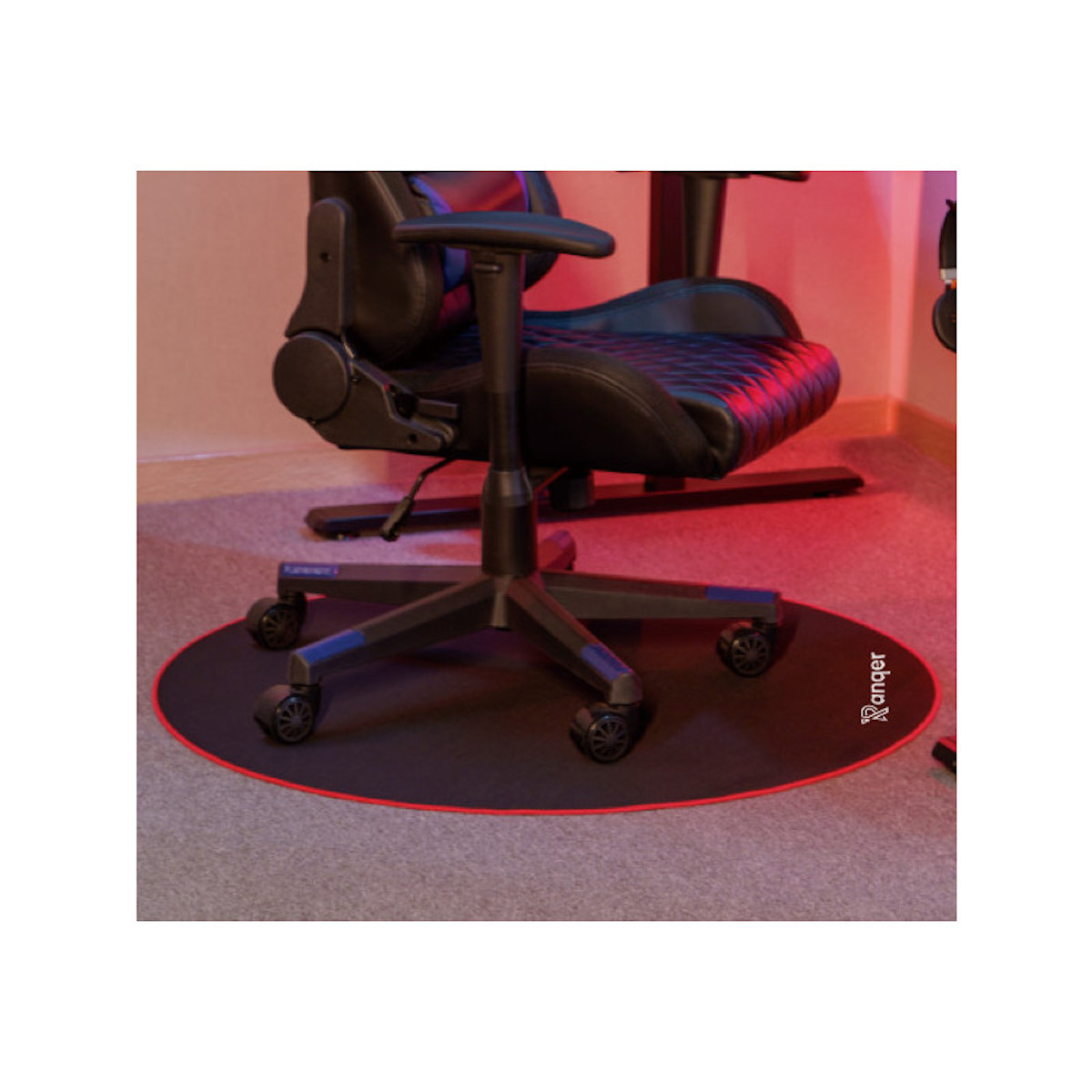 A black gaming chair on a black and red mat on a gray carpet. The background is white.