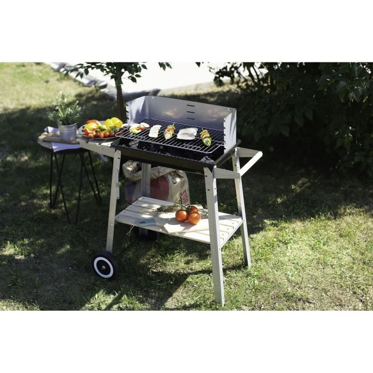Grillwagen mit Essen und Tisch. Grünes Gras, sonniger Tag. Weißes und schwarzes Design.
