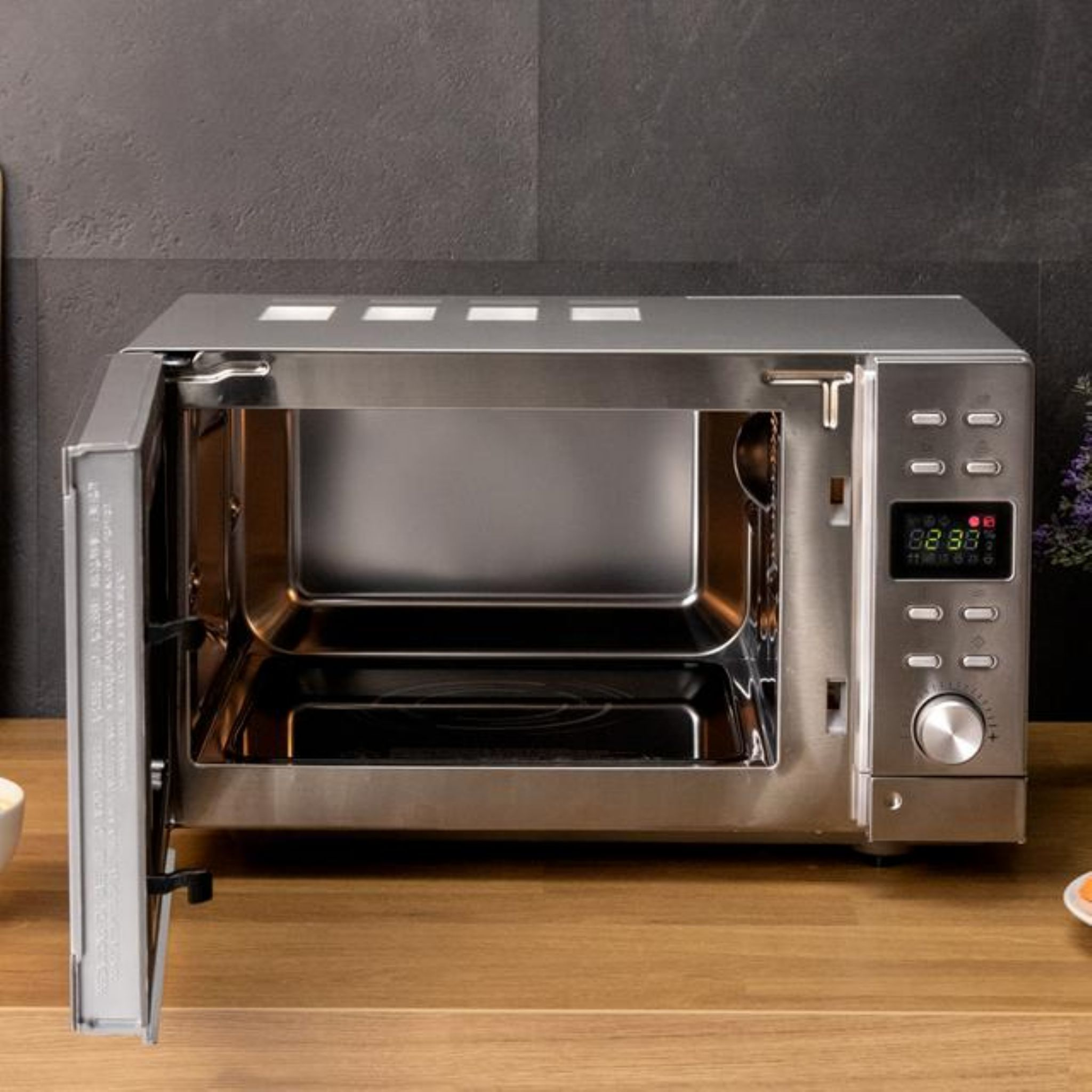 Kuchenka mikrofalowa z otwartymi drzwiami. Wnętrze ze stali nierdzewnej.