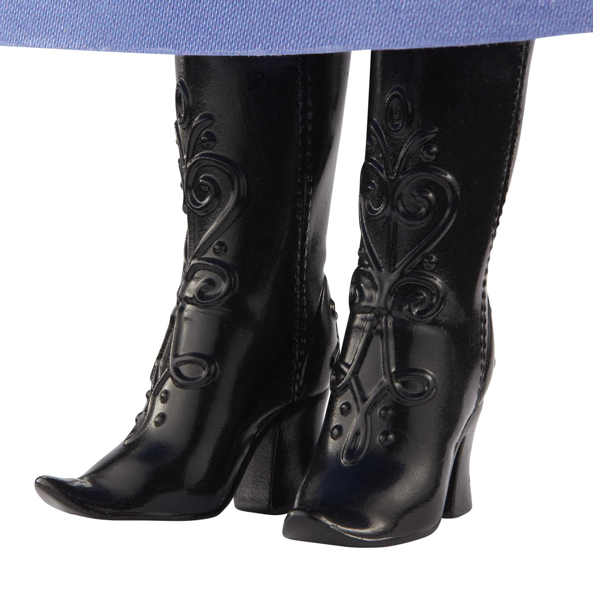 Zbliżenie czarnych butów na wysokim obcasie z dekoracyjnymi wzorami, noszonych przez lalkę, niebieska tkanina u góry.