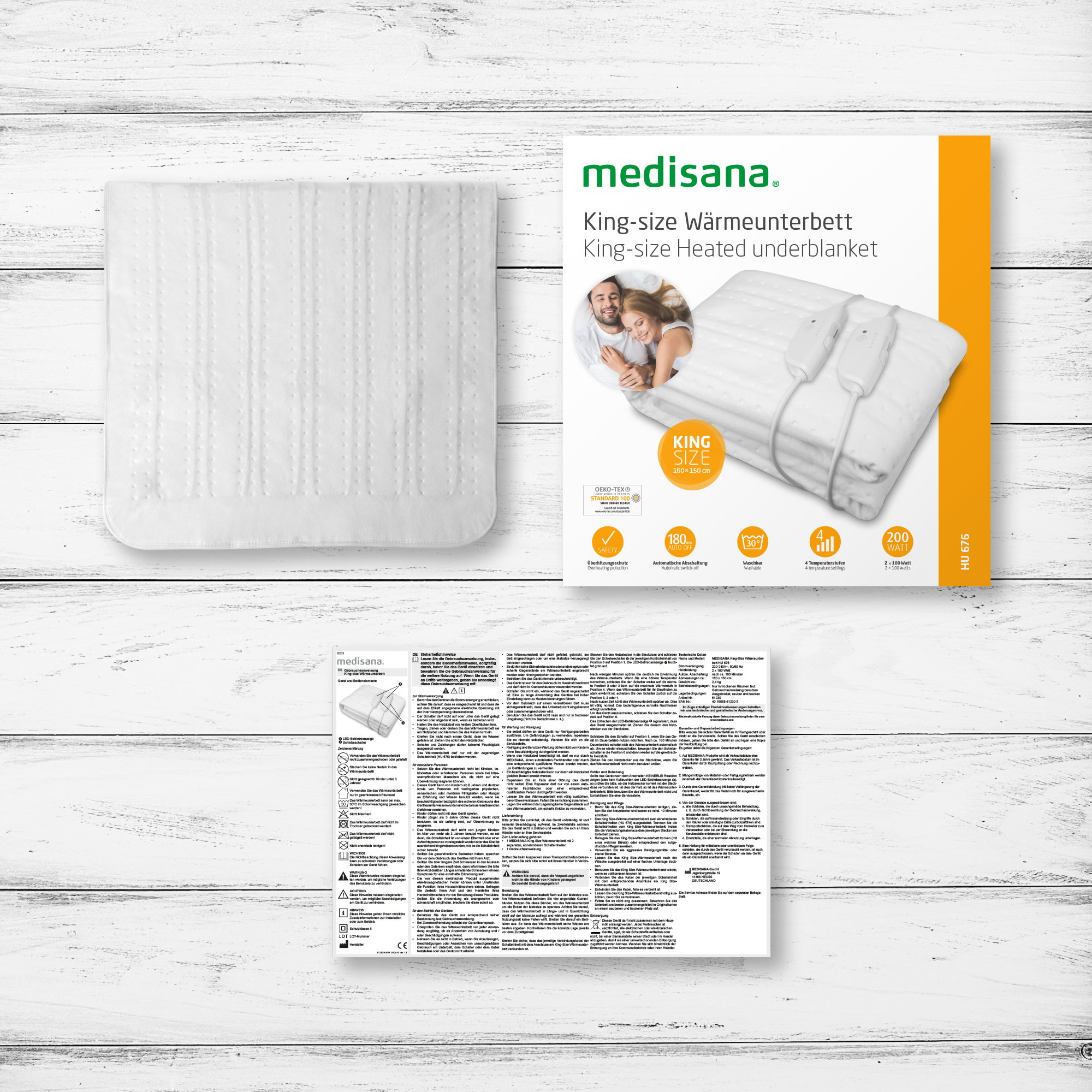 Elektryczny podkład grzewczy w rozmiarze king size i jego opakowanie, ułożone na drewnianej powierzchni.