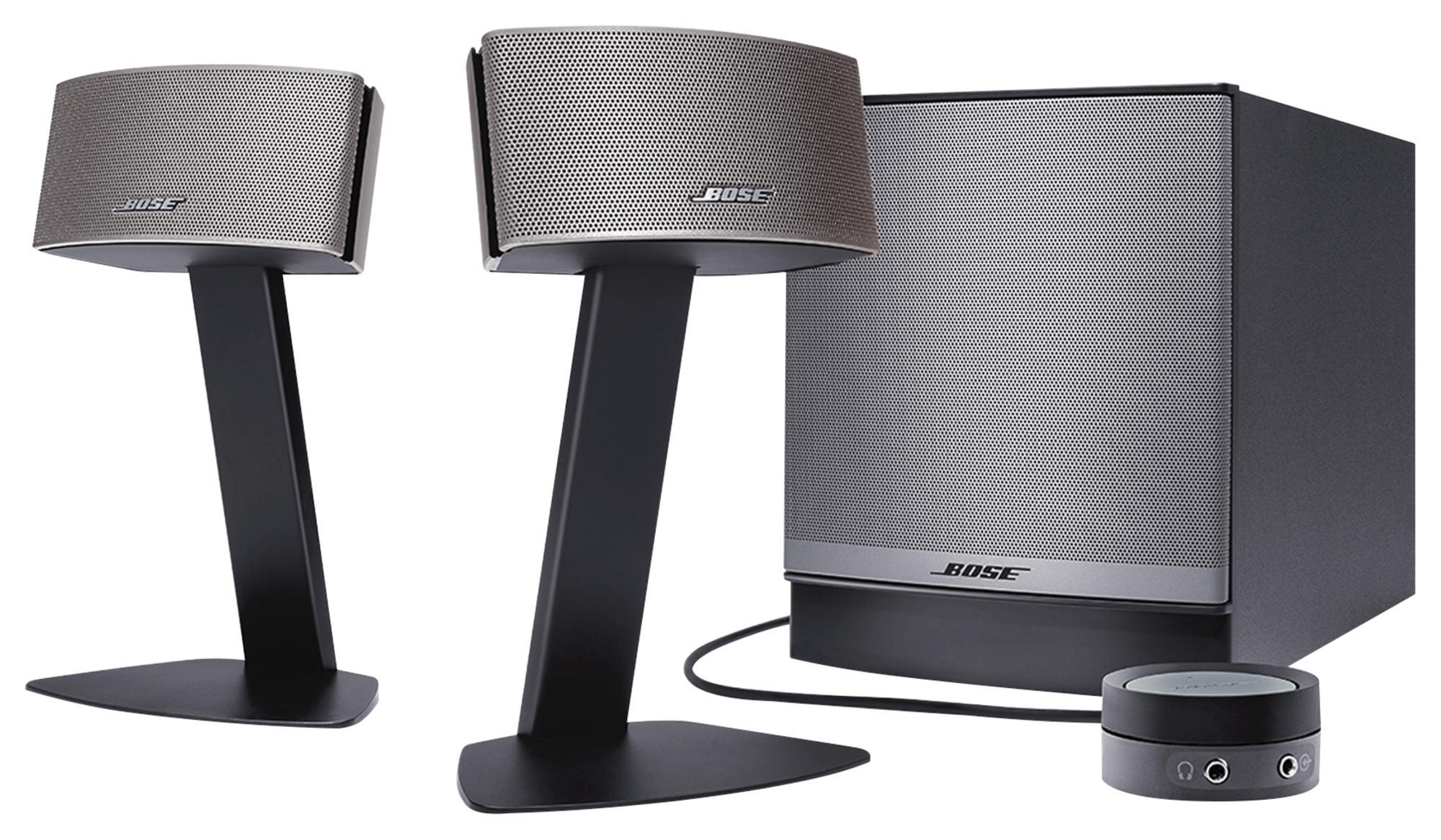 Zwei Bose-Lautsprecher mit Ständern und ein Subwoofer. Eine kleine Steuereinheit ist ebenfalls sichtbar.