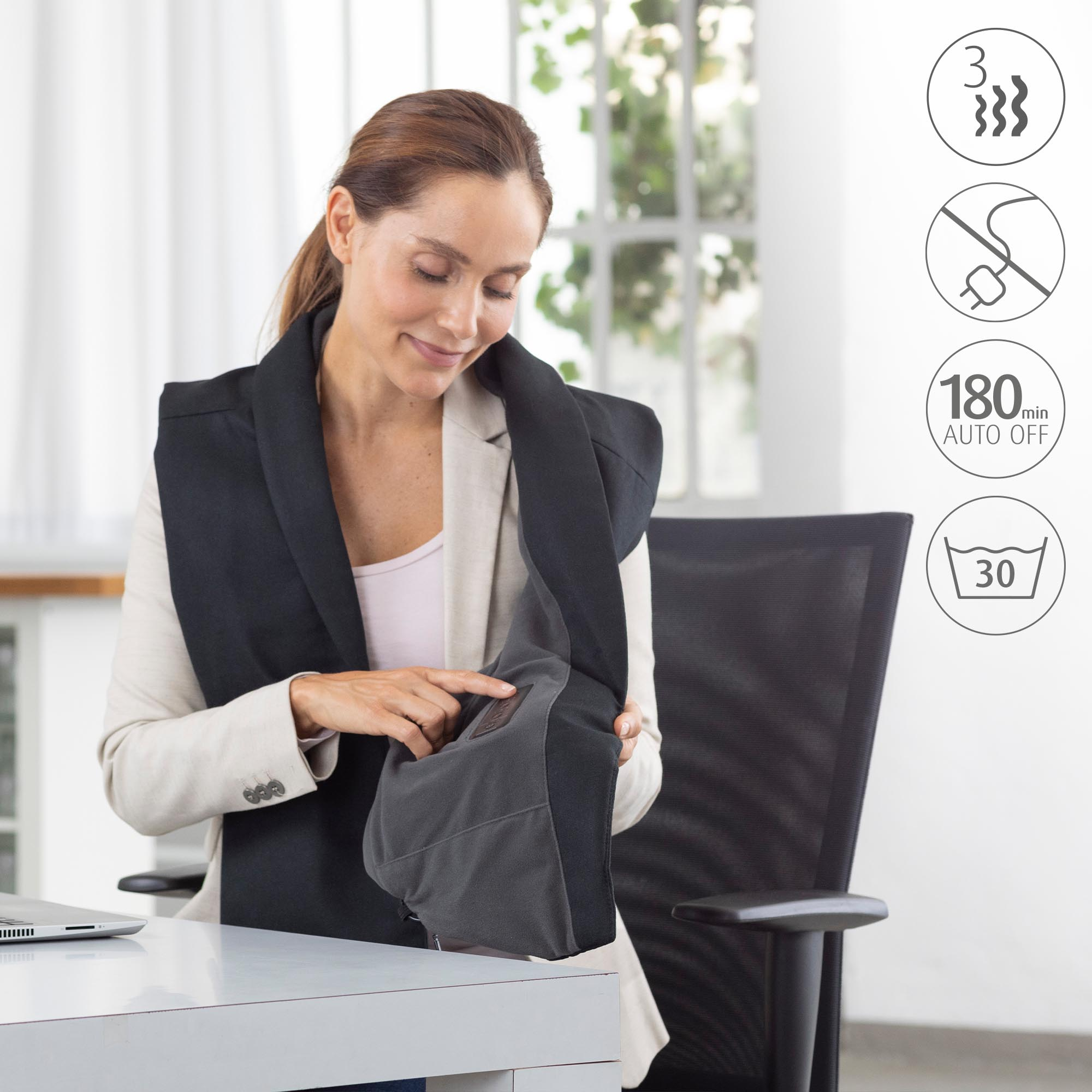 Una mujer con una blazer usa una envoltura térmica para el cuello con iconos de calor, energía y lavado.