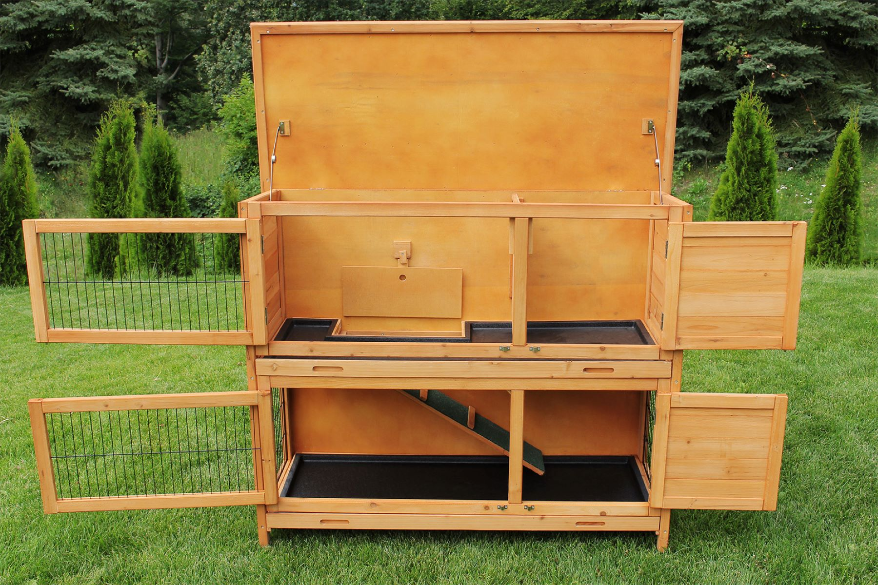 Offener Kaninchenstall aus Holz, zeigt zwei Ebenen mit Drahttüren, eine Rampe und einen erhöhten Bereich.