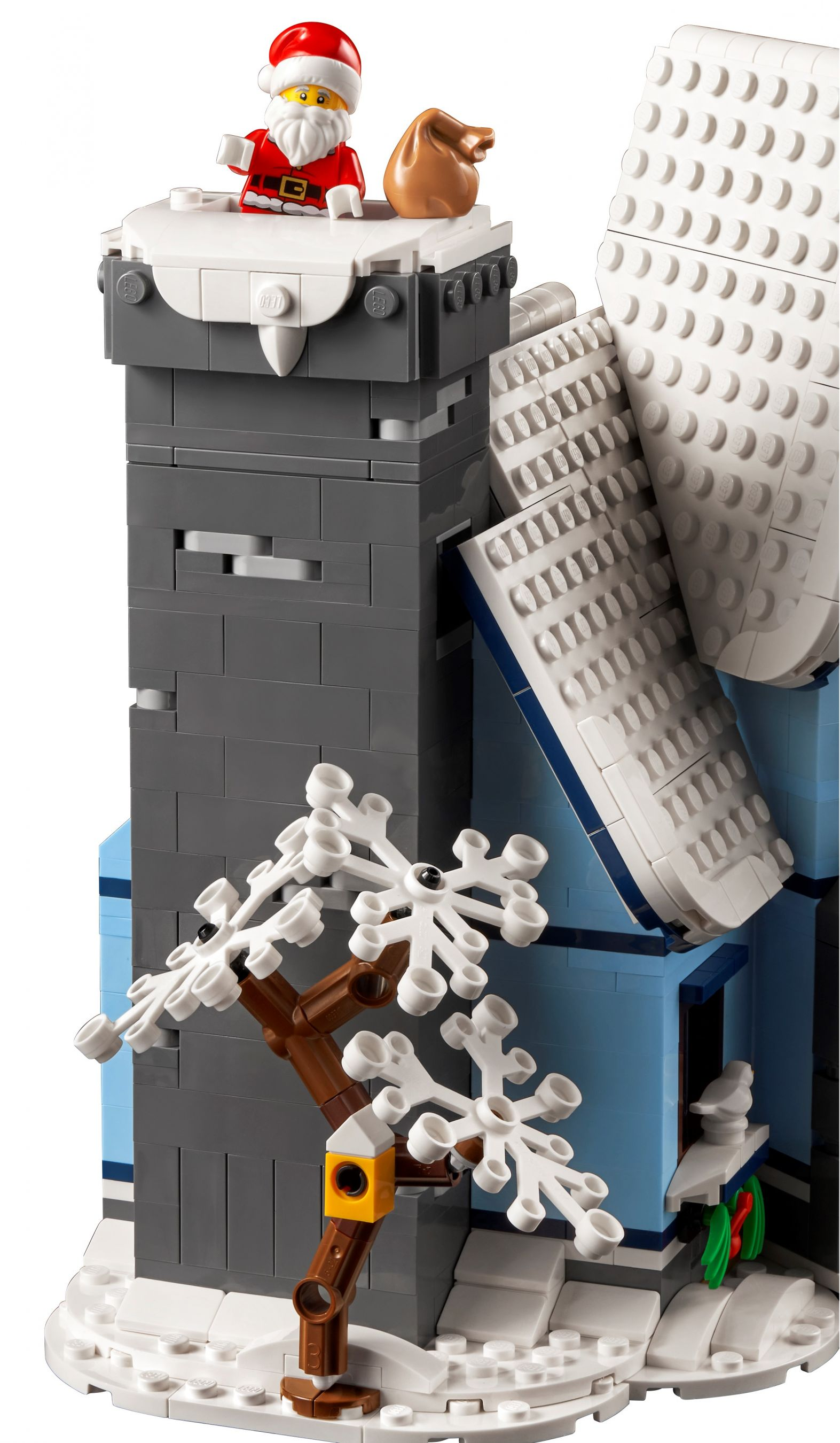 Lego Weihnachtsszene. Weihnachtsmann auf einem Turm, verschneite Dächer und ein dekorierter Baum. Weißer Hintergrund.