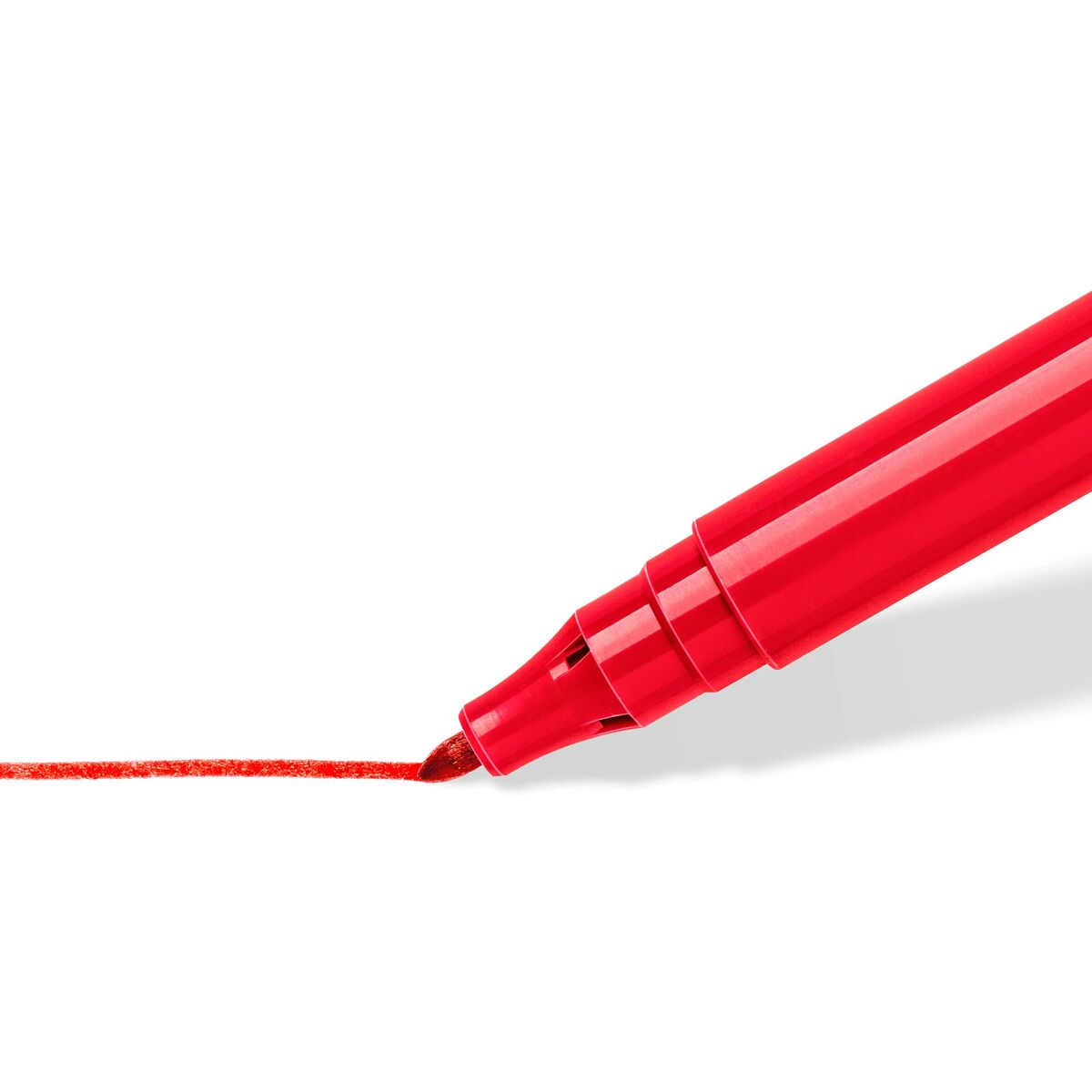 Roter Marker, der eine rote Linie auf einer weißen Oberfläche zeichnet. Die Spitze des Markers berührt die Oberfläche.