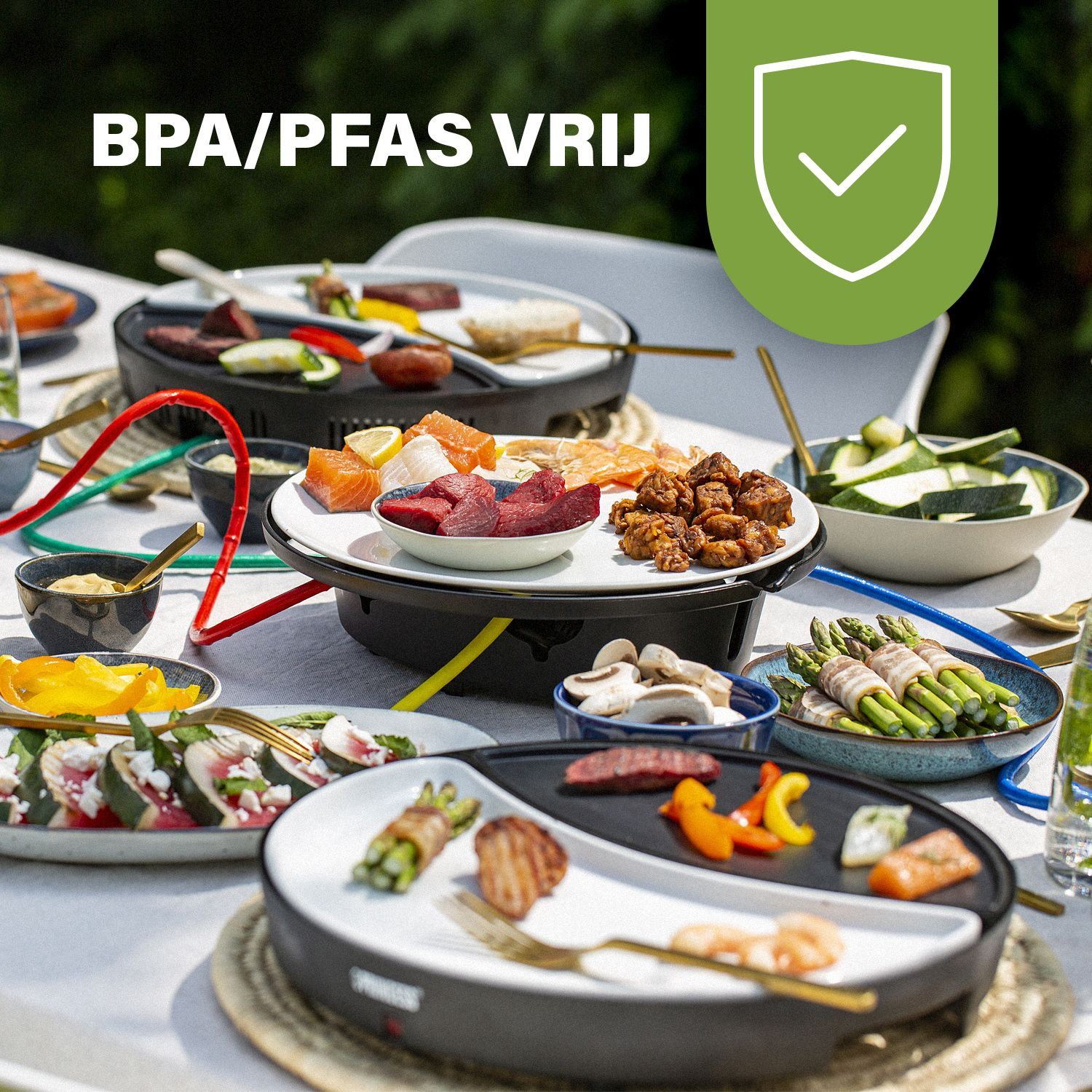 Scena na zewnątrz z jedzeniem na talerzach, grillem do raclette i różnymi składnikami. Etykieta: 'Bez BPA/PFAS'.