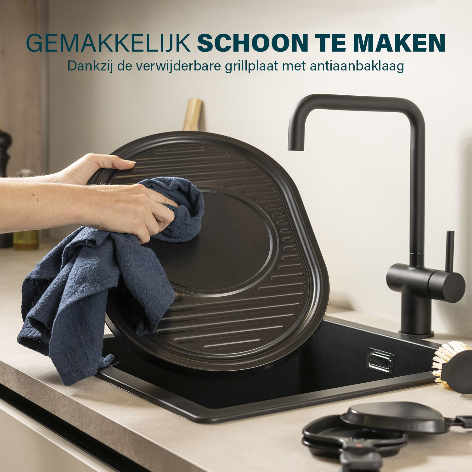 Osoba czyszcząca patelnię grillową w zlewie. Patelnia jest czarna, a zlew jest czarny.