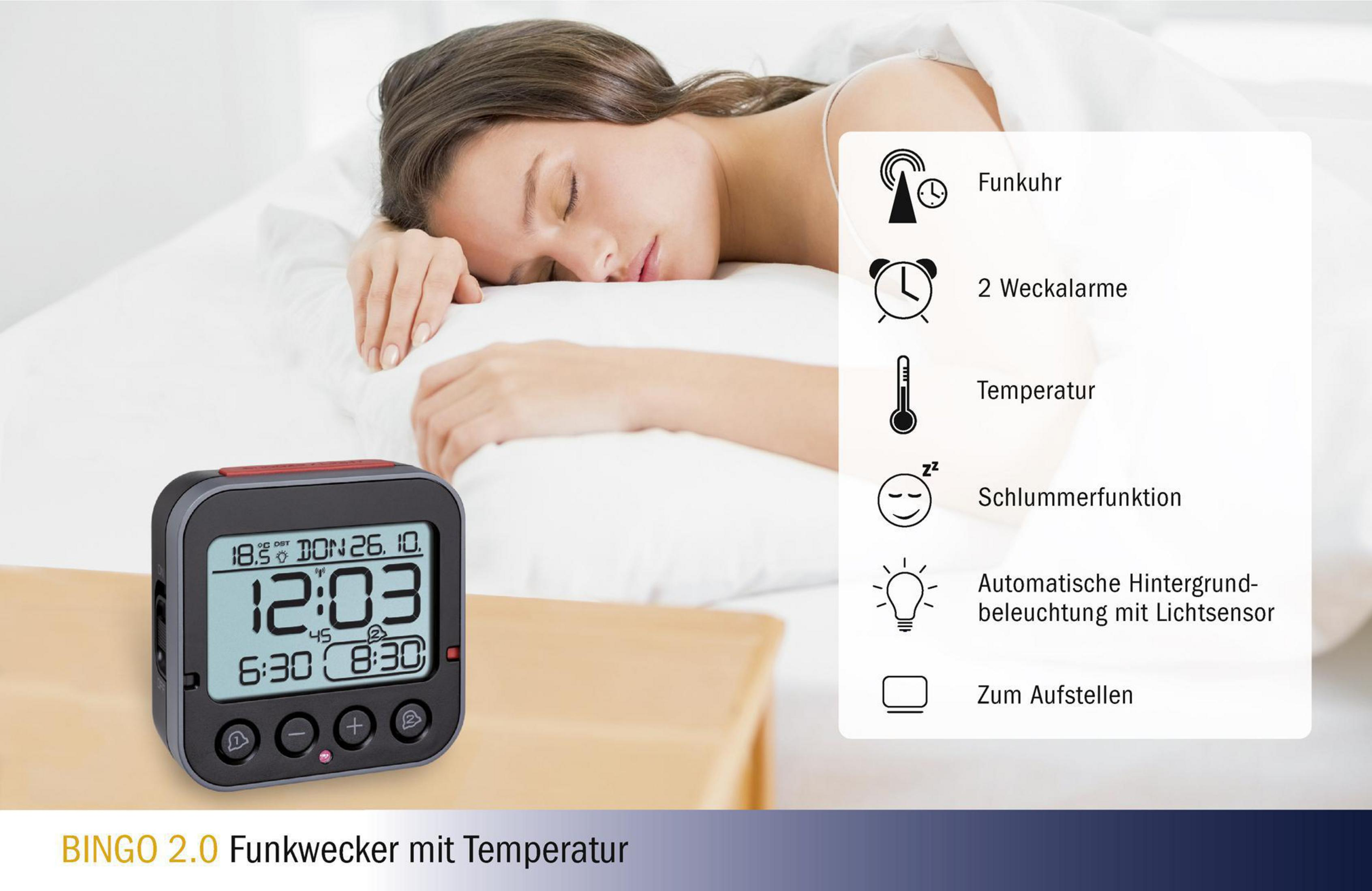 Digitaler Wecker mit schlafender Frau im Bett.