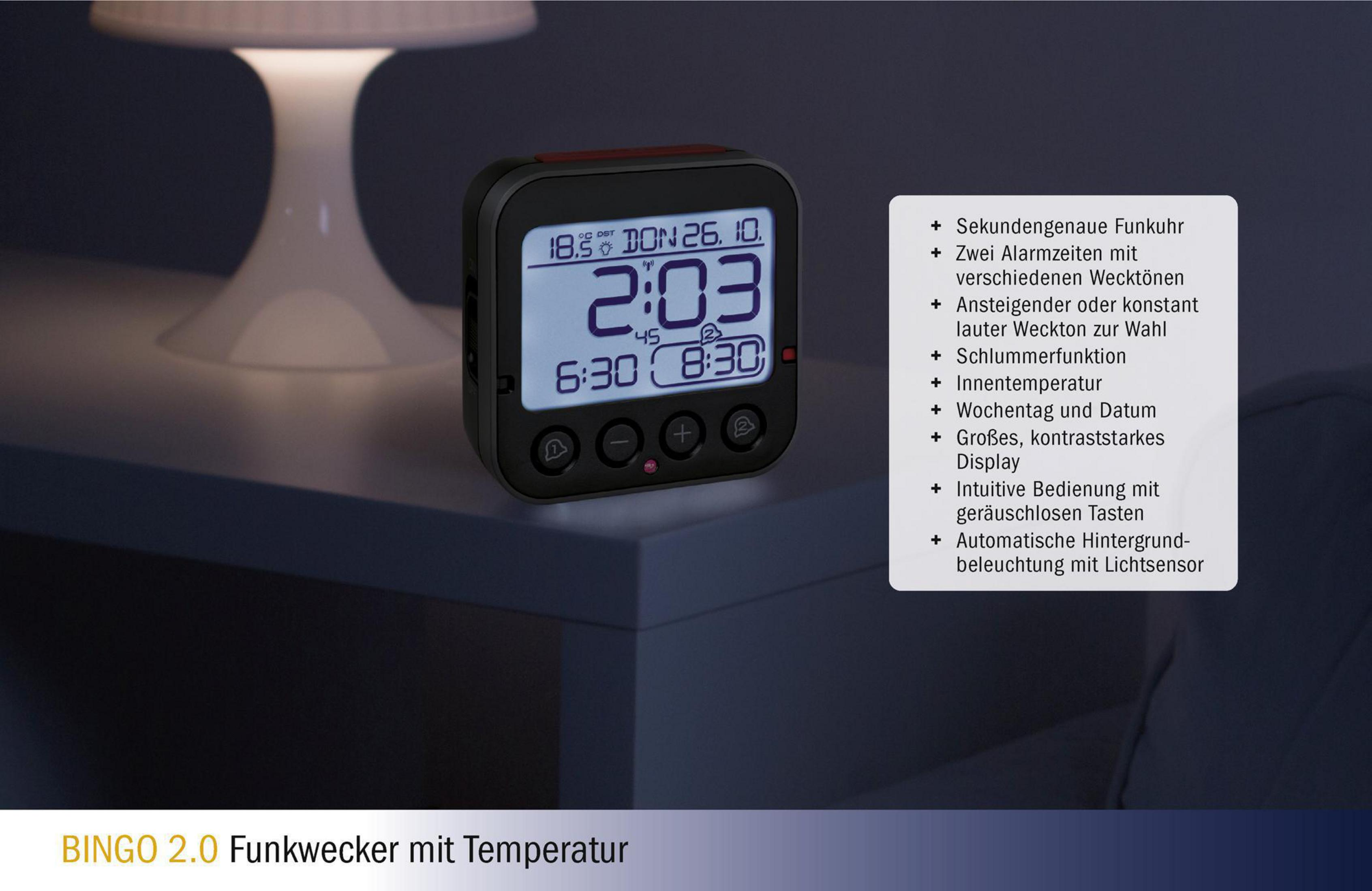 Digitaler Wecker auf einem Nachttisch. Zeigt Uhrzeit, Datum und Temperatur an. Weißer Text auf Schwarz.