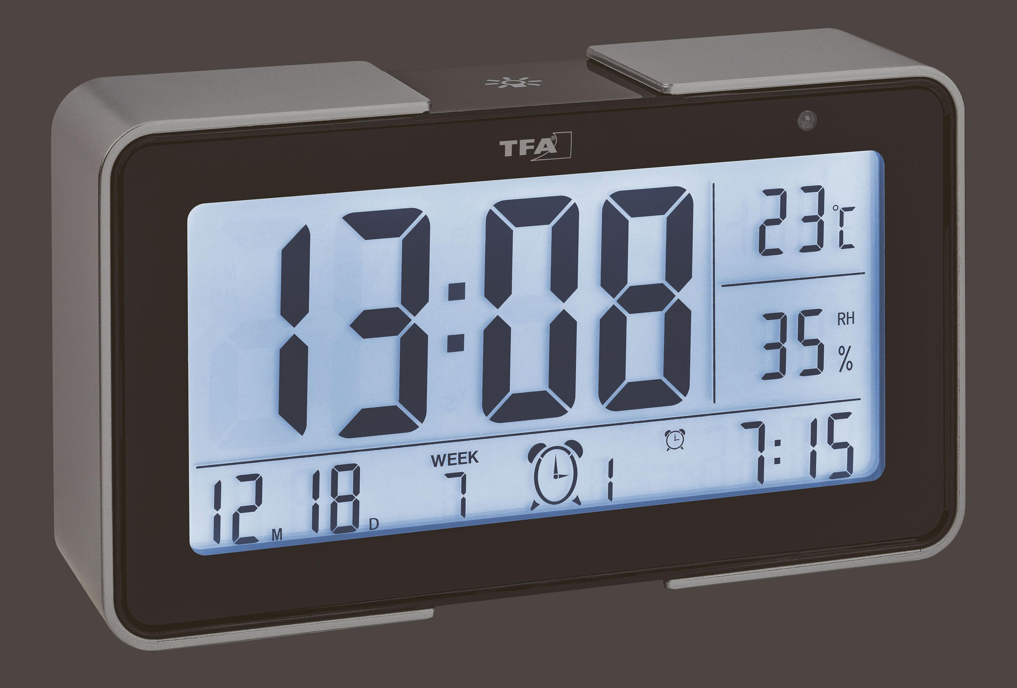 Digitaler Wecker mit Anzeige von Zeit, Tag, Datum und Temperatur. Silberner Rahmen, schwarzes Display.